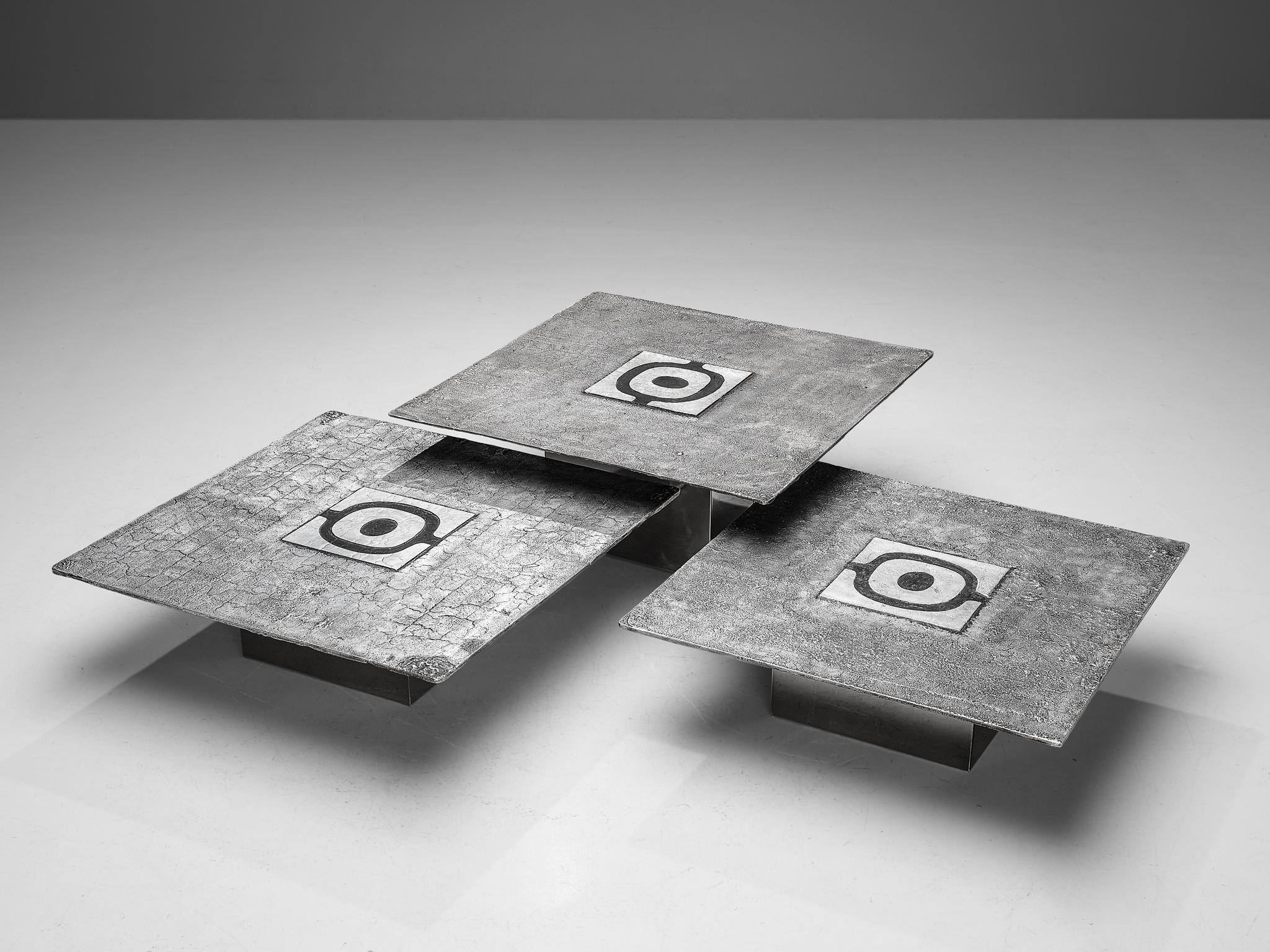 Willy Ceysens, set of three coffee tables, cast aluminum, Belgium, 1970s. 

This remarkable set is a true eye catcher with its outstanding cast aluminum exterior. The silver square tabletop with an eye-like engraving in the middle forms the center