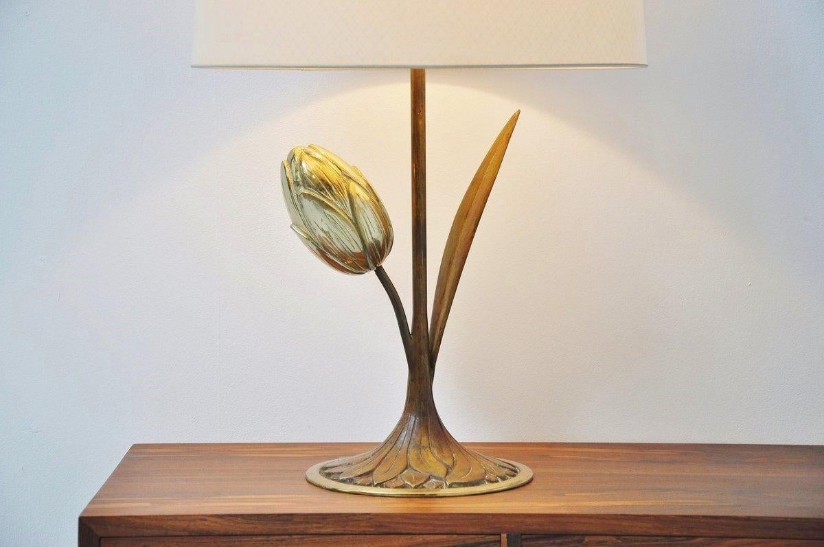 Very nice large and decorative table lamp in the manner of Maison Charles and Willy Daro, Belgium 1970. This table lamp has a brass base, lily tulip shaped and has an off white fabric cylindrical shade. The lamp gives very nice and warm light when