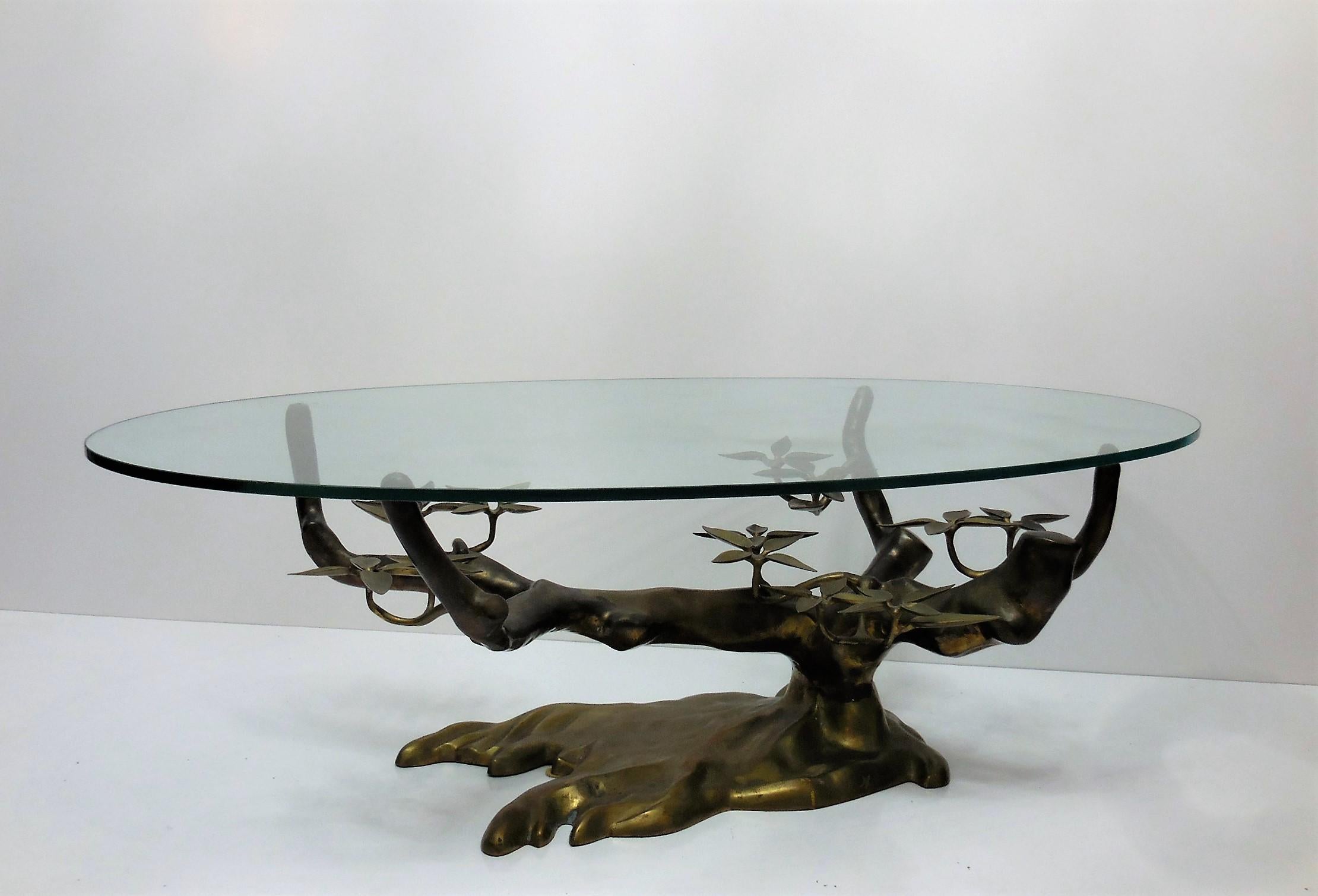 Spectacular table. A stylized version of a bonsai tree with an oval glass top. Beautiful age appropriate patina. Glass top measures 53