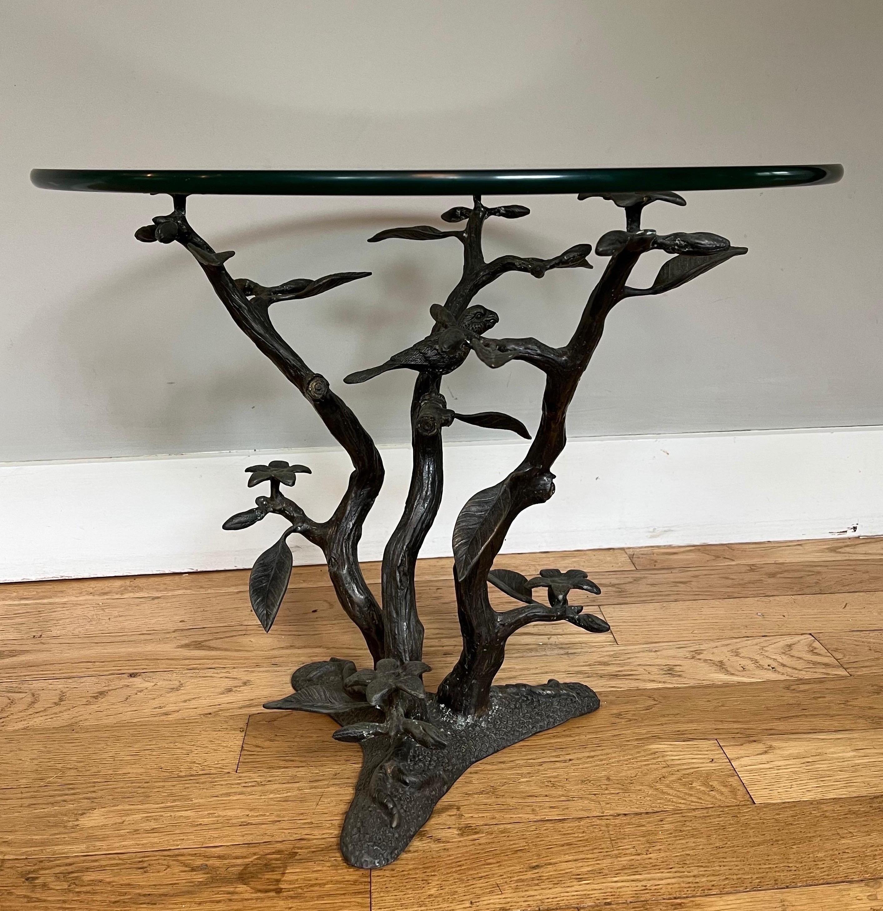 This is a stunning vintage brass / bronze end table featuring an intricate bird, flower, and tree base with a round glass top by Willy Daro. 

Belgium circa 1970s.

