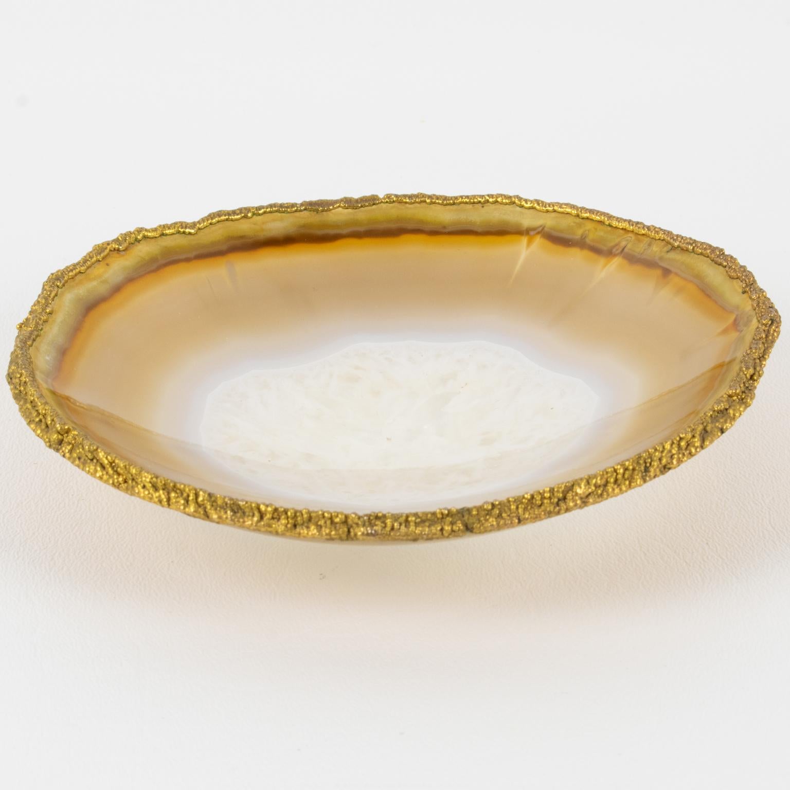 This elegant natural agate stone modernist desk tidy, or vide poche, is reminiscent of Willy Daro's work. The catchall features a natural agate stone rounded raised bowl with a gilded bronze trim and color swirlings. There is no visible maker's