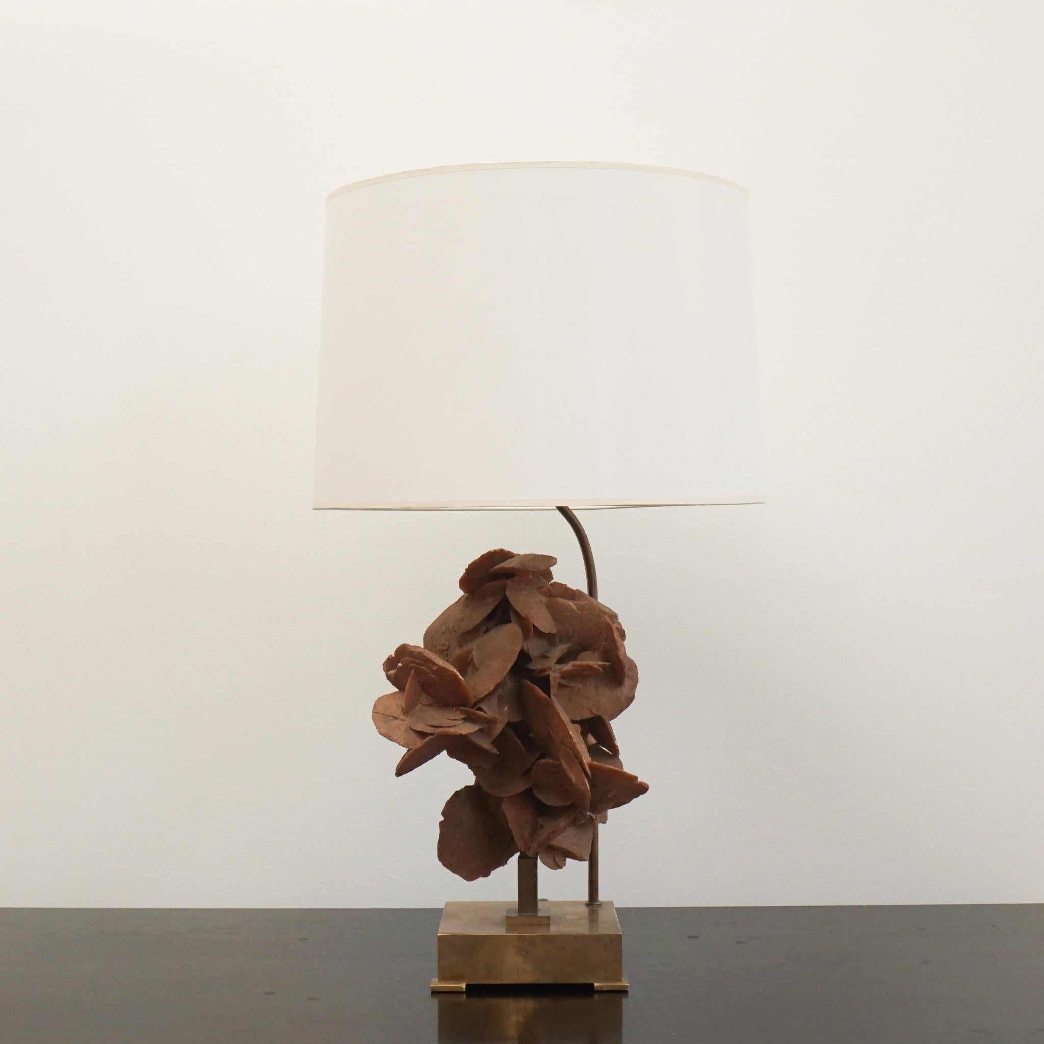 This 1970s Sandstone and brass table lamp is a rare find. Created by Belgium designer Willy Daro, it features a sandstone bloom on a small footed brass base. Topped with a crisp white drum shade, the lamp is sculptural, functional and representative