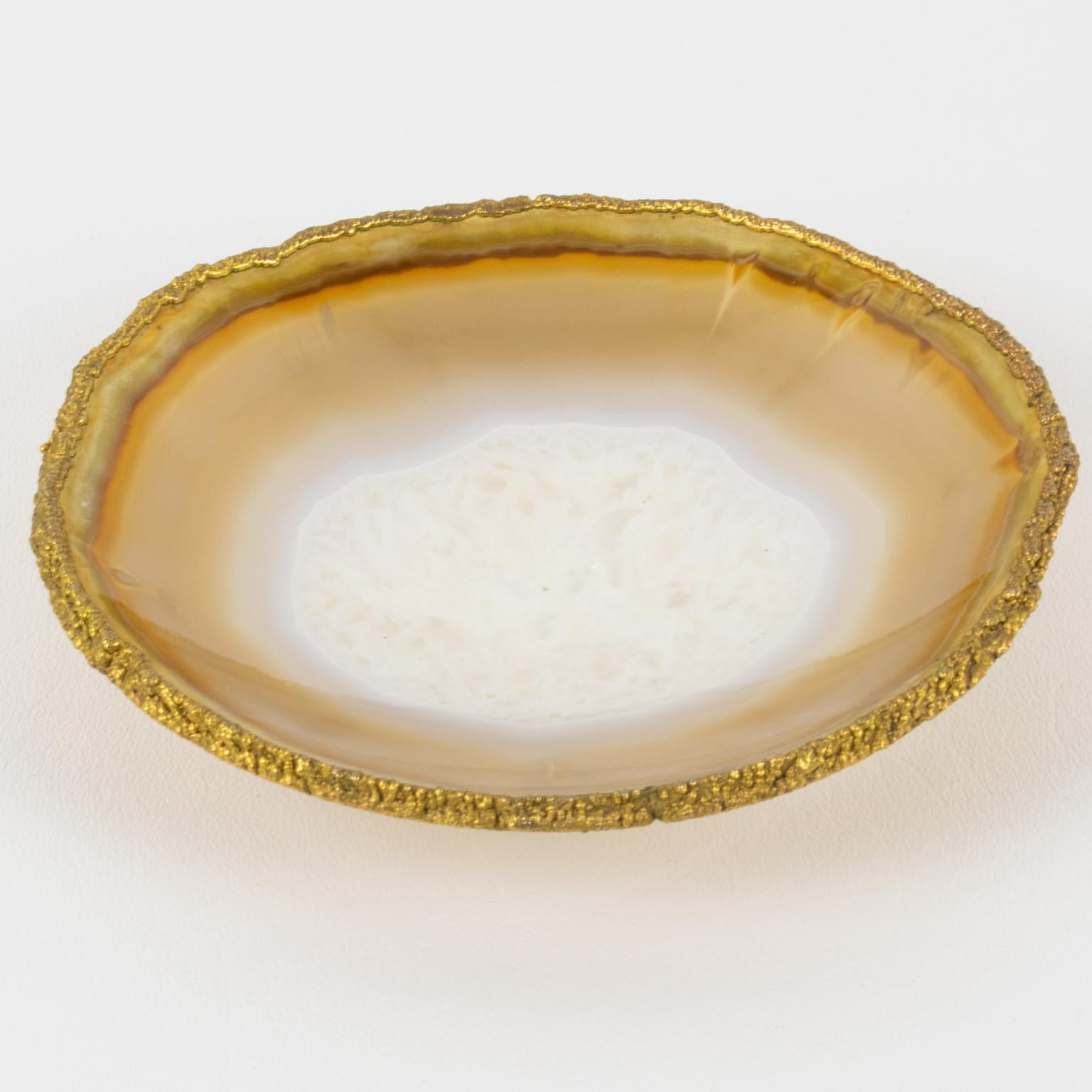 This elegant modernist natural agate stone desk tidy, or vide poche, is reminiscent of Willy Daro's work. The catchall features a natural agate stone rounded raised bowl with a gilded bronze trim and color swirlings. There is no visible maker's