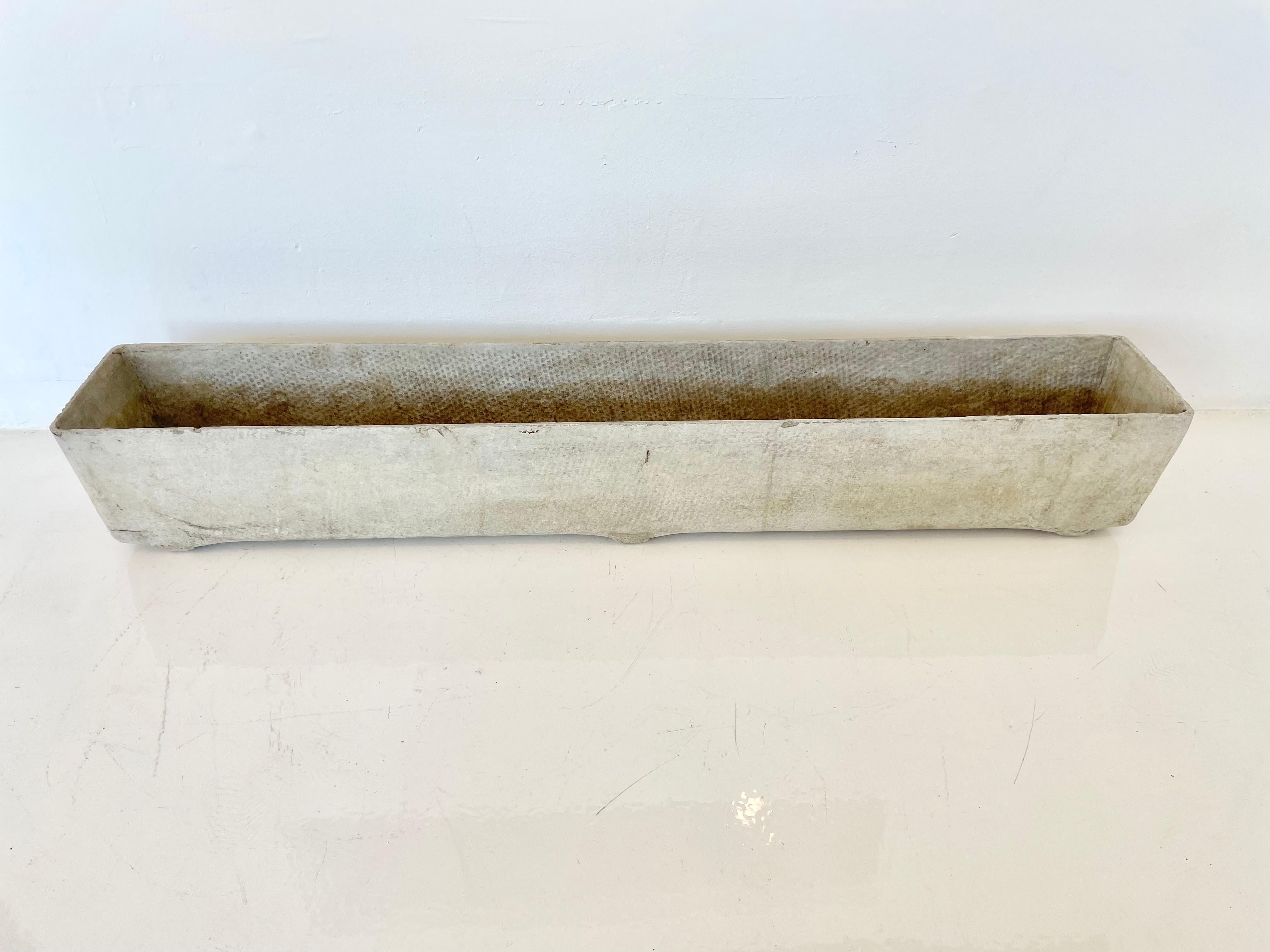Concrete trough planter by Swiss architect Willy Guhl. Just under four feet long. Factory drilled drainage holes. Perfect depth for narrow spaces. Small rounded feet on underside of planter. Great condition. Measure: 47