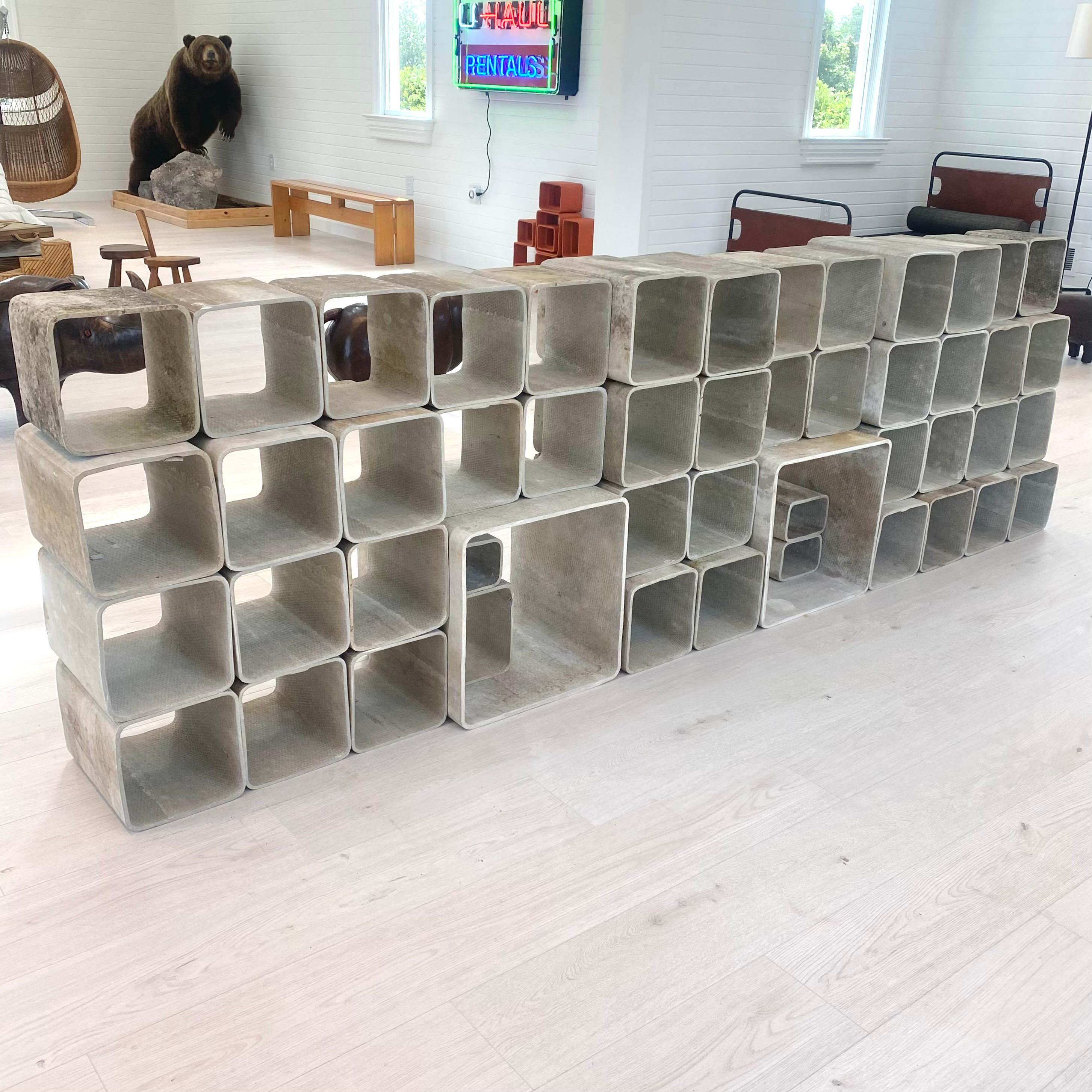 Stunning monumental 50 piece concrete bookcase by Willy Guhl. Made up of 4 different sized hand-made concrete cubes. Completely modular and able to be arranged in a multitude of ways. Original concrete color. Varying degrees of patina and moss