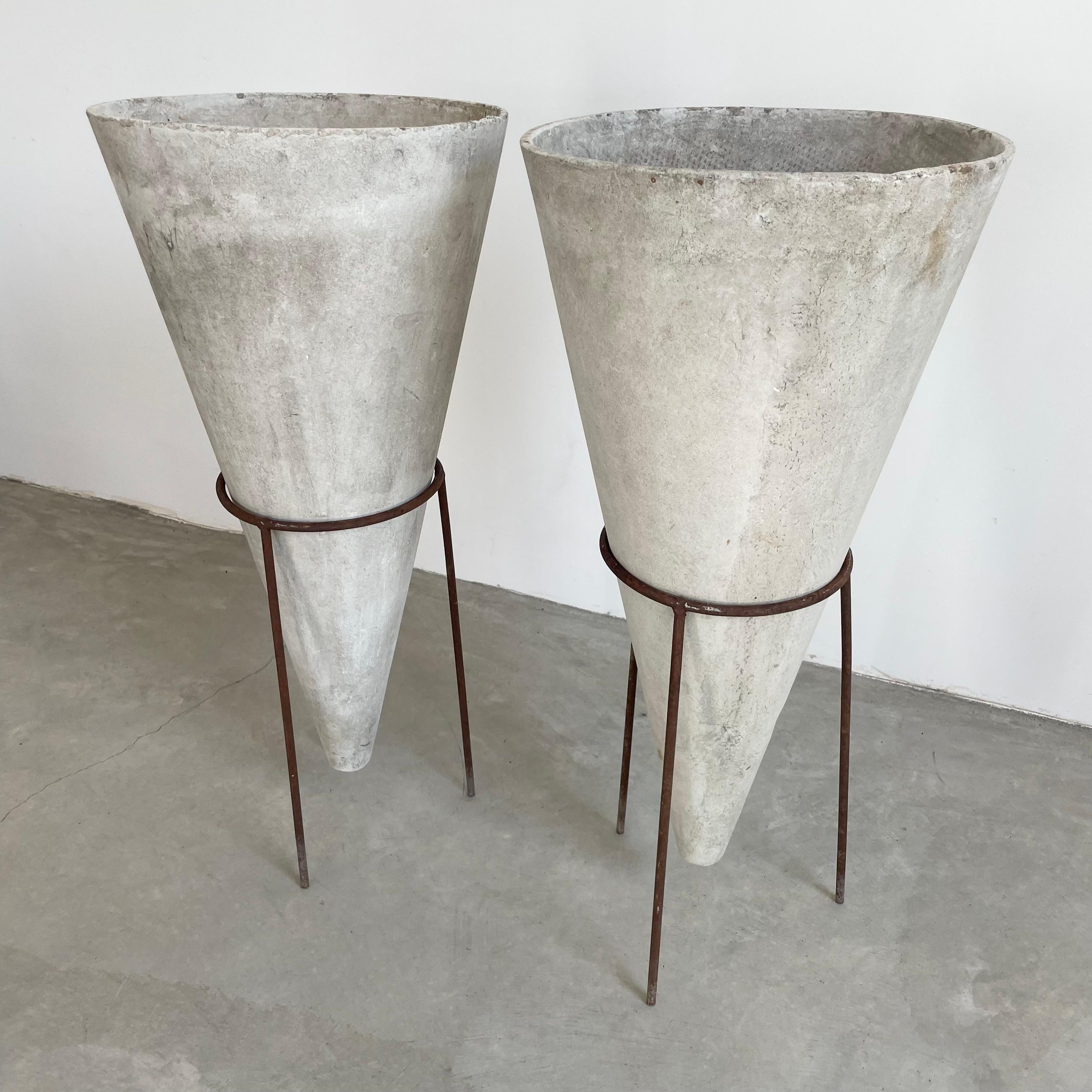 Unusual concrete cone planters by Will Guhl. Handmade in the 1960s, in Switzerland. 3 Feet tall. Cones dated on inside; 1968 and 1965 pictured above. Inverted concrete cone sits comfortably in a tall slender iron tripod stand. Bottom of cone floats