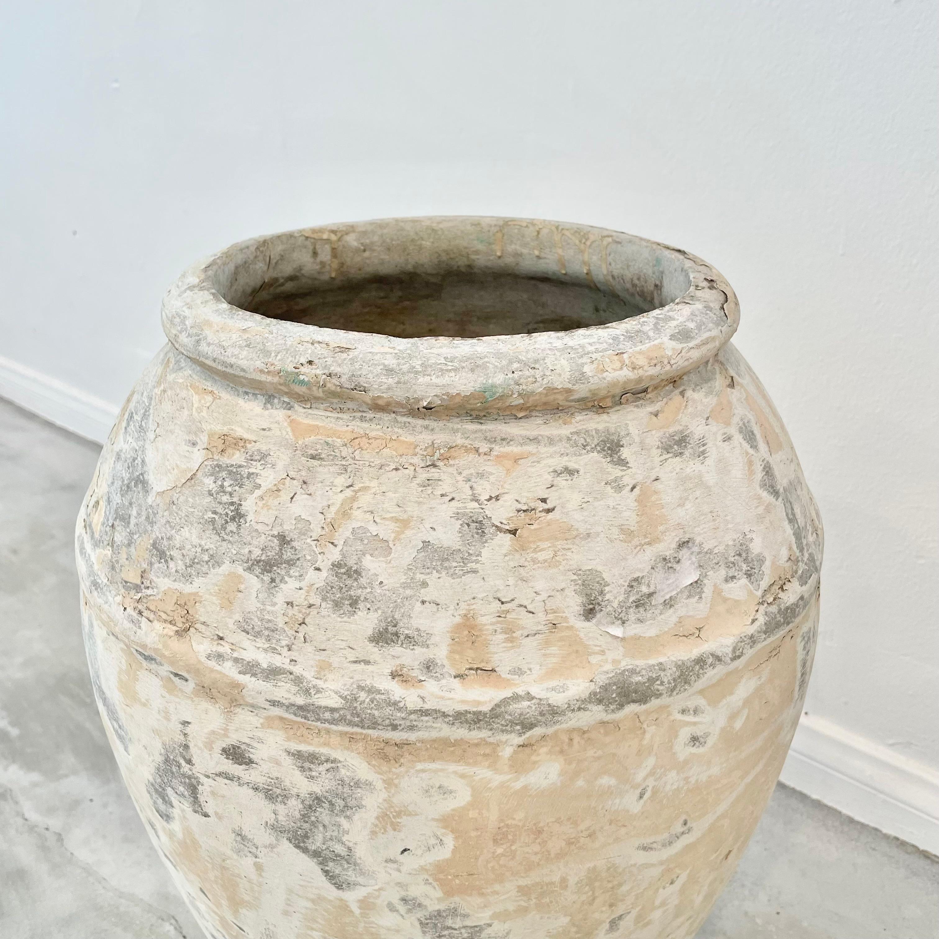 Concrete urn by Willy Guhl. Rare model. In a beautiful washed out patina from layers of finishes worn down over the years. Urn has a delicate cement ridge around the mouth as well as around the widest part of the jar giving it depth and delicate