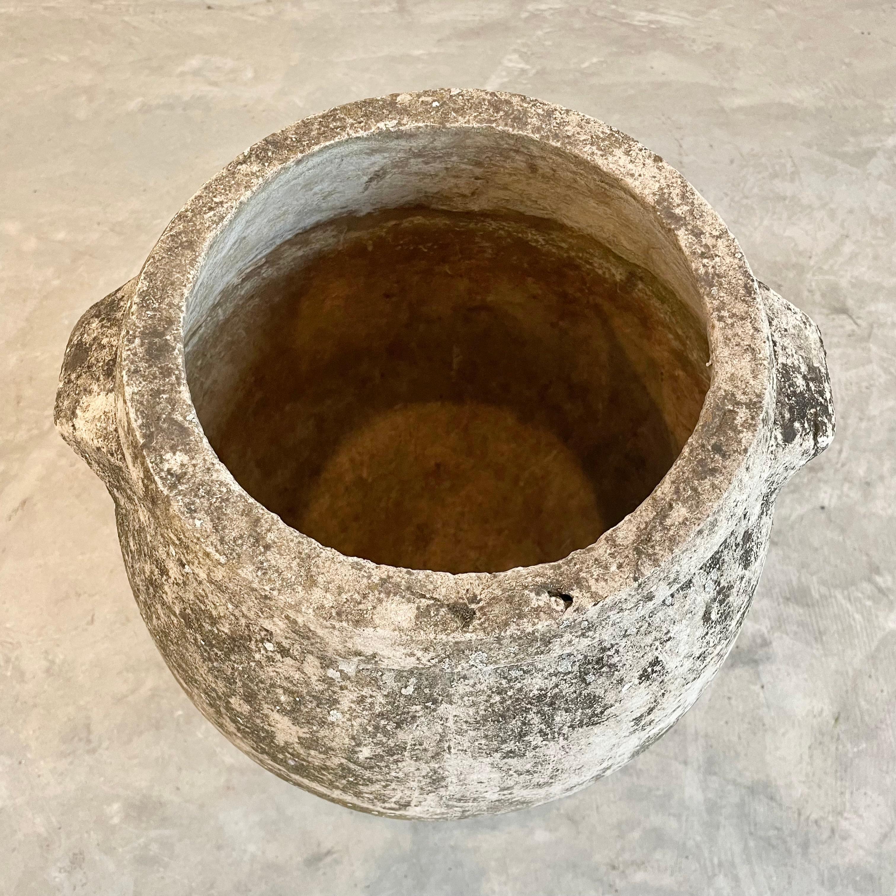 Concrete urn by Willy Guhl in a beautiful heavy patina from years of Swiss weather. Urn has a delicate cement ridge around the mouth and two handles right under the upper rim. The body of the jar tapers down to the bottom. Great vintage condition.