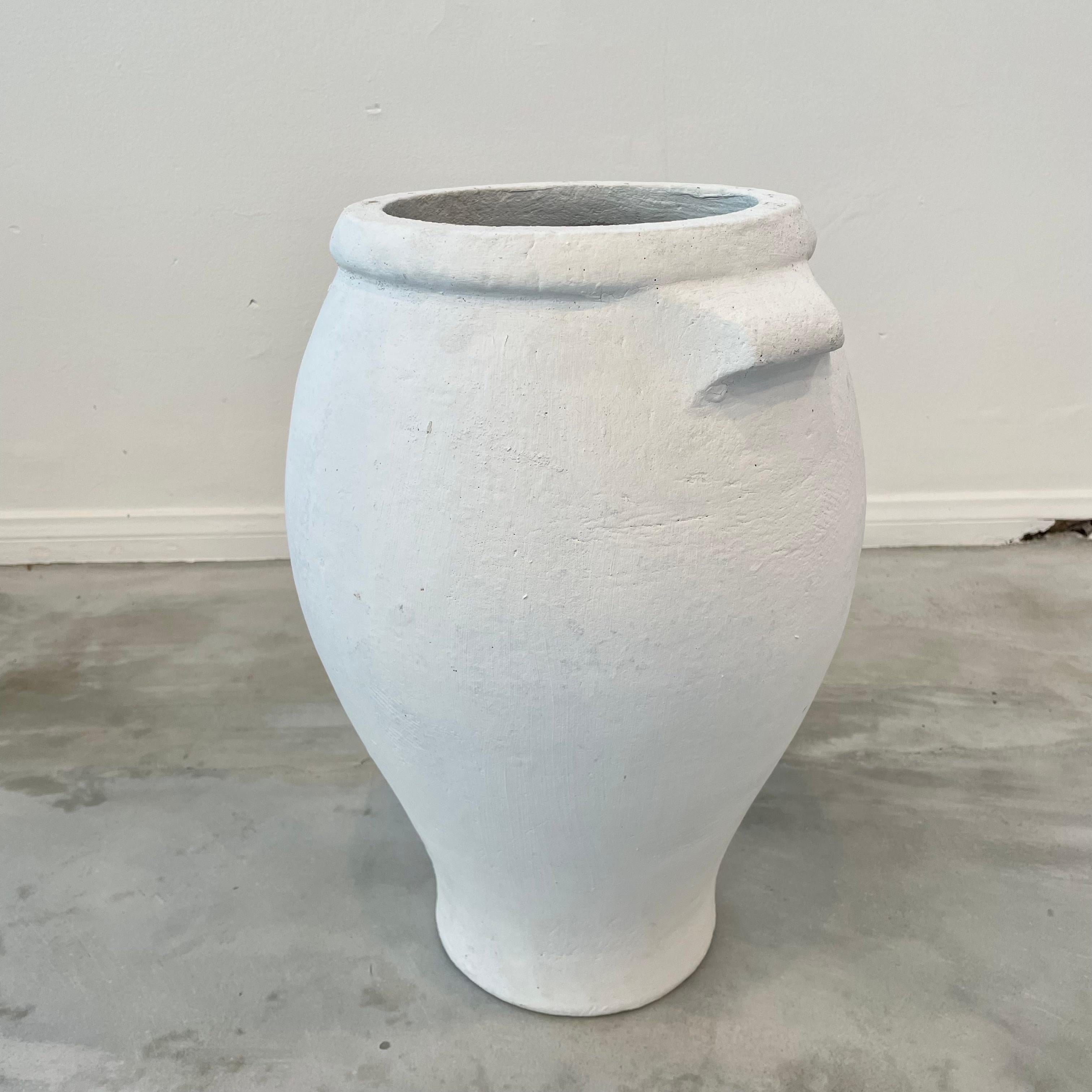Concrete urn by Willy Guhl in a heavy matte white paint. Urn has a delicate cement ridge around the mouth and two handles right under the upper rim. The body of the jar tapers down to the bottom. Great vintage condition. Only one available.
