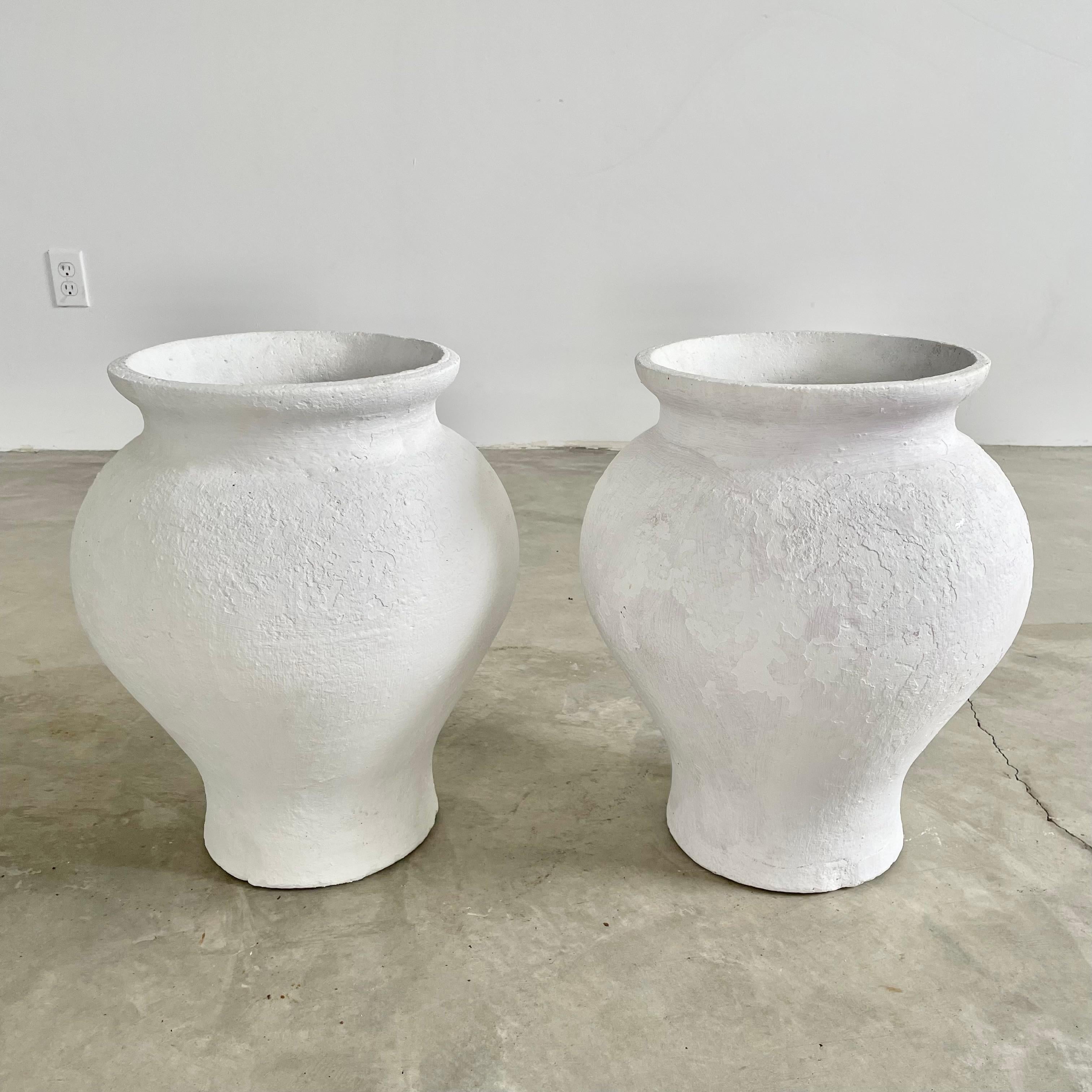 Beautiful concrete vases by Willy Guhl. Thick walls with years of patina both hand painted in a matte white paint. Delicate and classic lines that start with a thin tapered base and rise to a billowed out body. The vase again tapers in at the neck