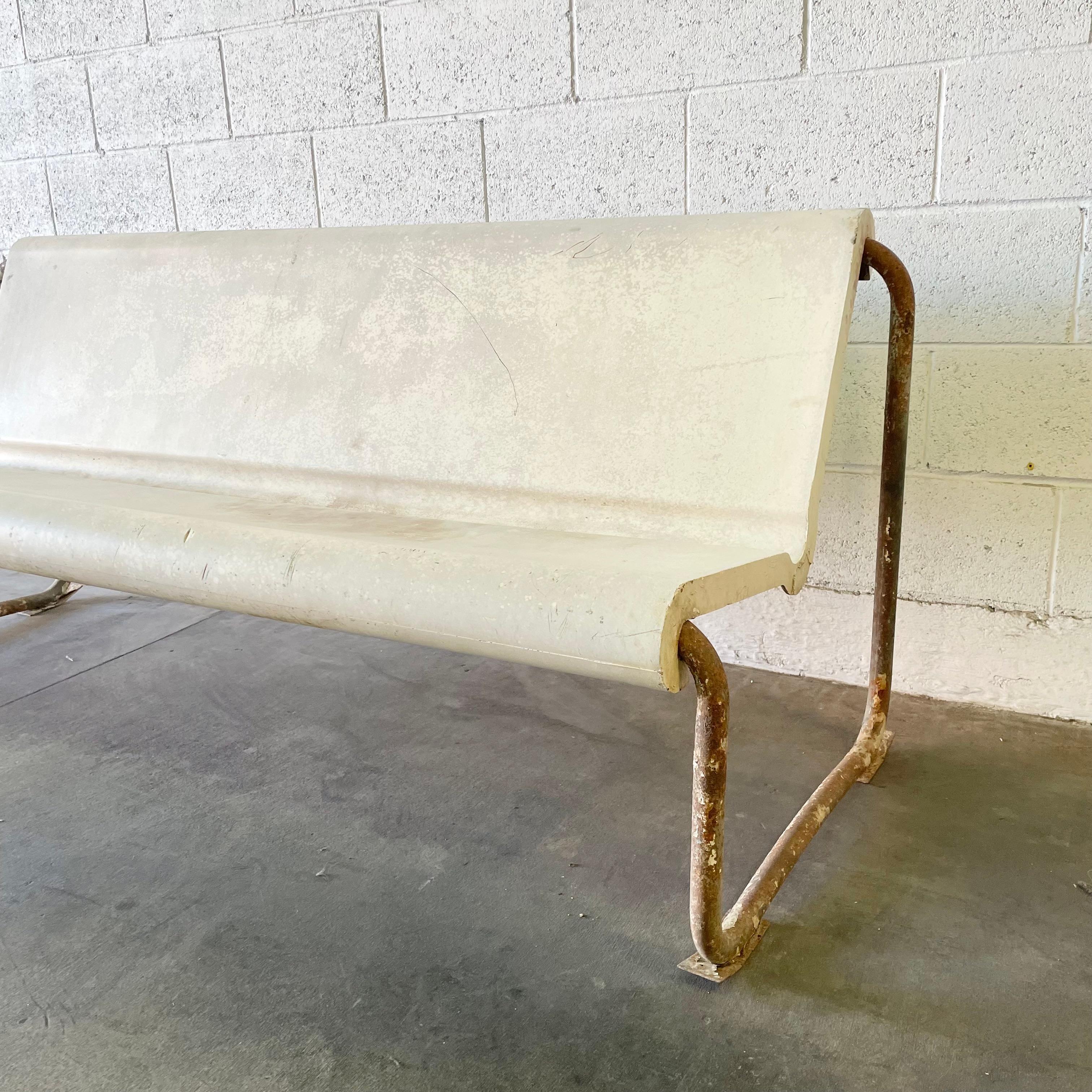 A remarkable midcentury floating bench by Swiss Architect Willy Guhl. Circa 1960s. Perfect minimal design as is common with the Swiss designer. The cream seat is made of fiberglass and is suspended by a tubular metal frame. Incredible patina to both