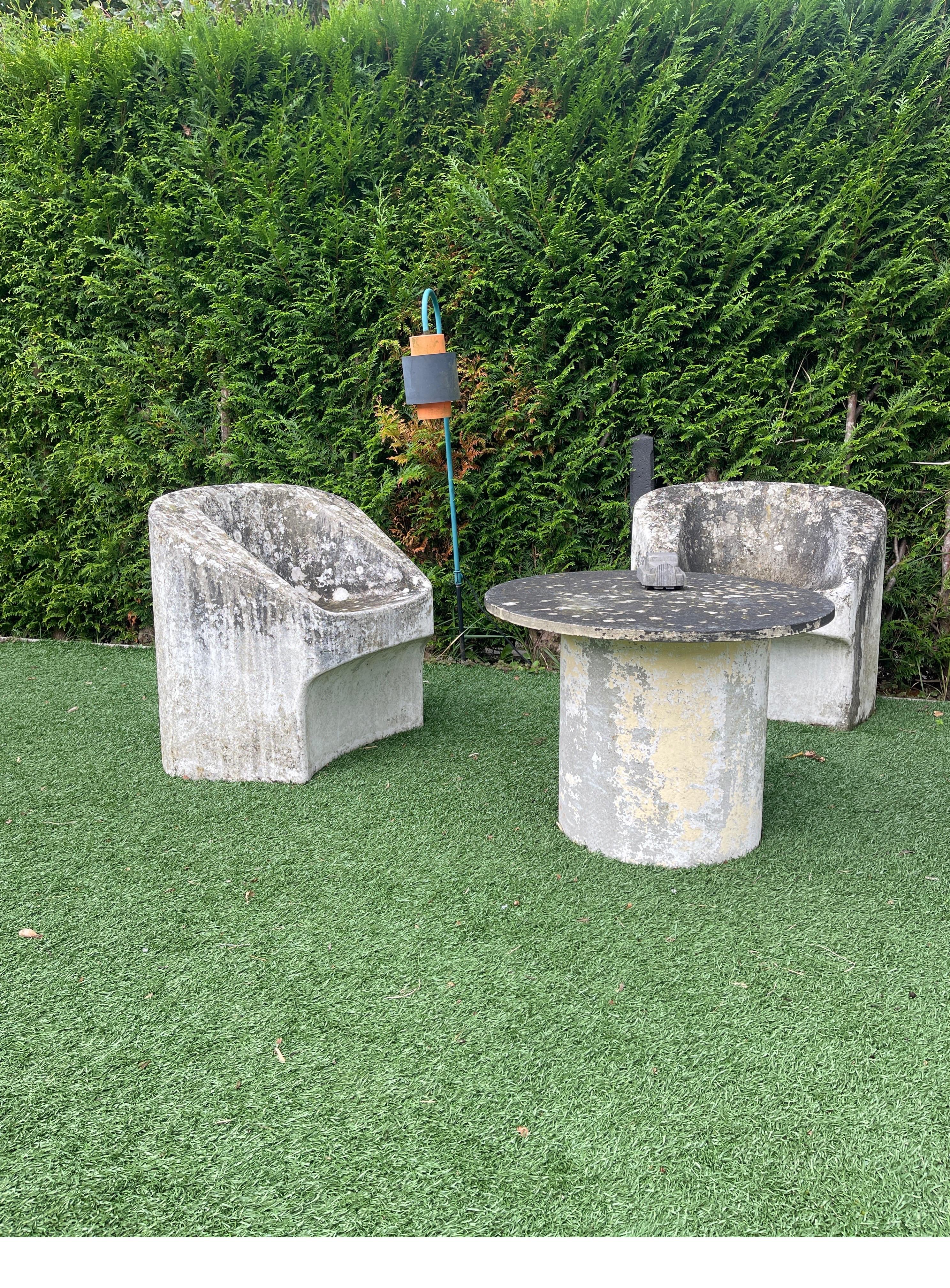 Introducing an extraordinary trio of Modernist concrete garden chairs with the accompanying table by the renowned Willy Guhl for Eternit. These pieces proudly bear the distinct Eternit number embossed stamp, originating from 1974 Switzerland. As