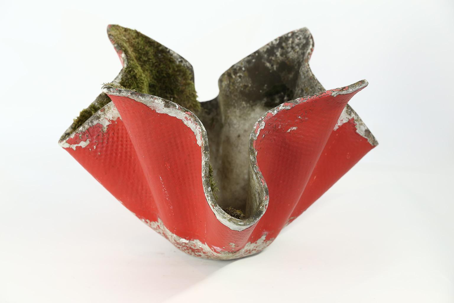This is a concrete planter designed by Swiss architect Willy Guhl. The planter, in the shape of a lotus flower, has been painted red. This lovely piece for the home or garden could be used as a planter or sculpture.