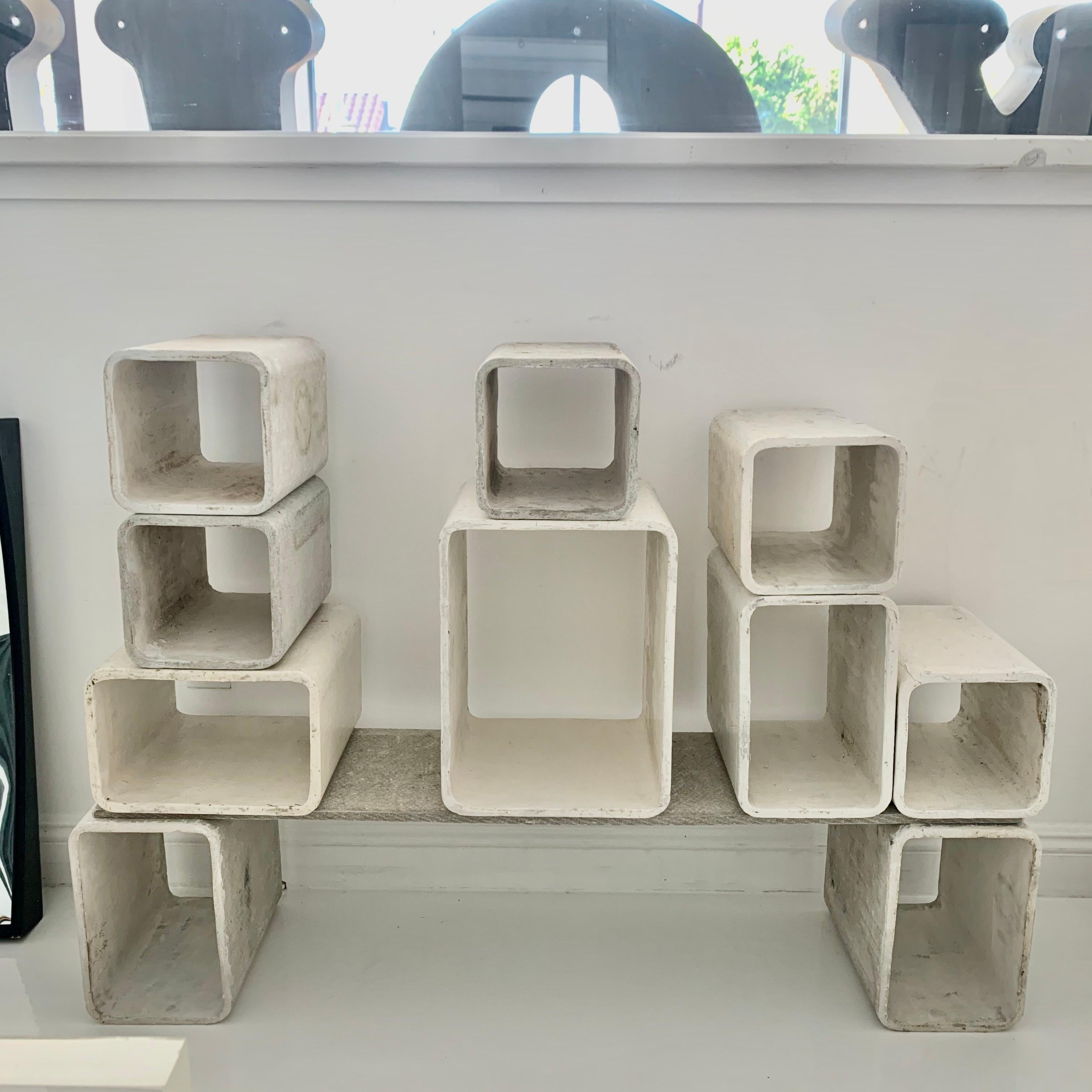Sculptural concrete bookcase by Swiss architect Willy Guhl. Handmade in Switzerland in the early 1960s. Produced by Eternit. Set consists of 10 concrete cubes and one concrete shelf. Cubes can be arranged in various ways. Great display