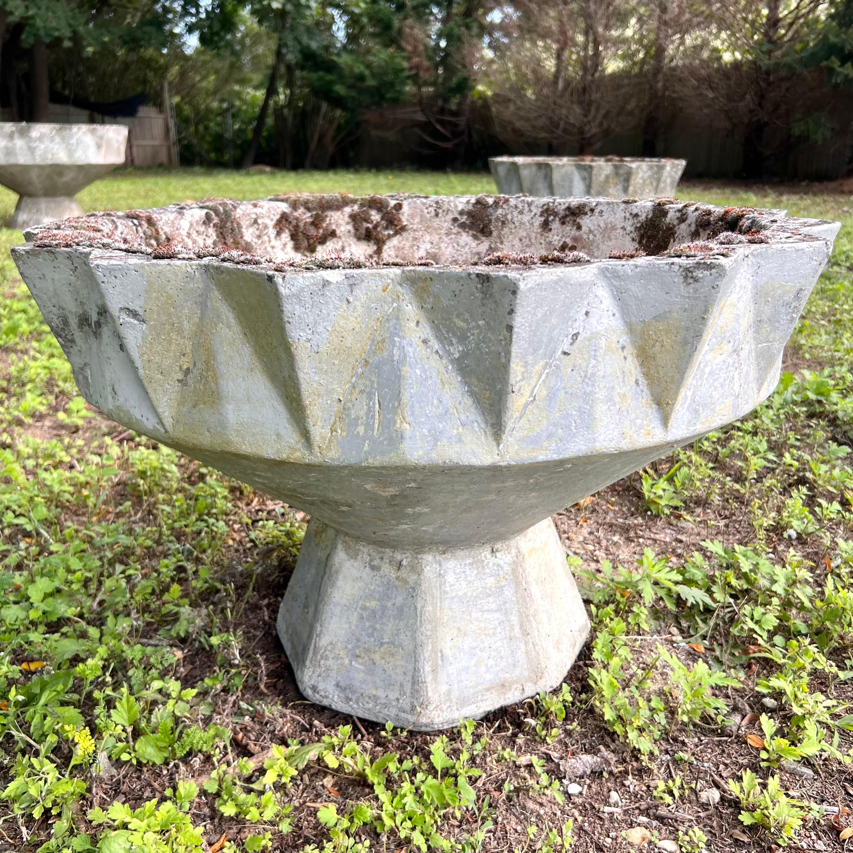 Stunning concrete planter by Swiss architect Willy Guhl. Faceted edges around the top and bottom. Planter in the shape of a chalice. Good vintage condition. Decades of age and patina from European winters. Multiple planters available in this size in