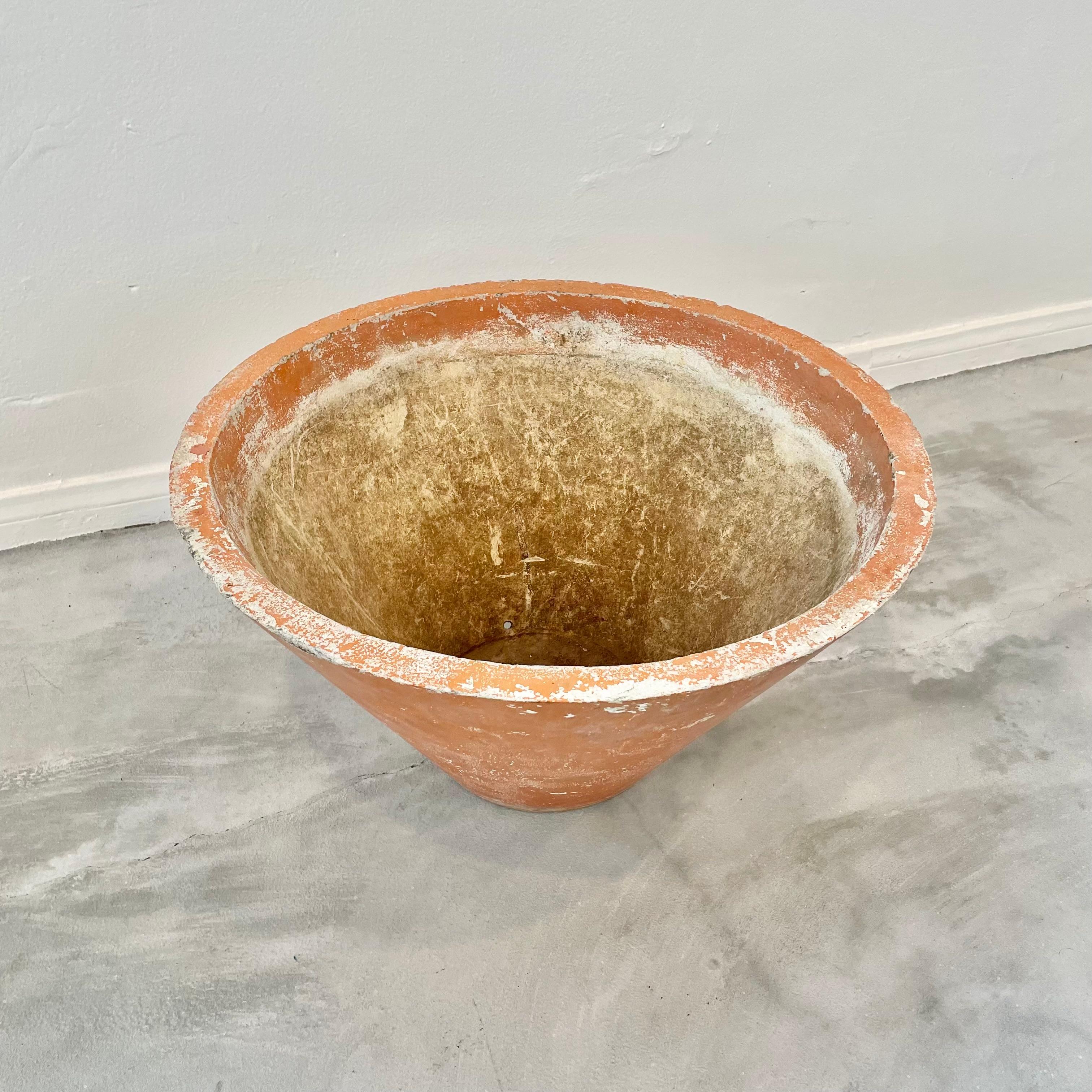 Beautiful concrete cone flower pot by Swiss architect and industrial designer Willy Guhl. Made in the 1960s in Switzerland. Wonderful faded terracotta-coloured patina across the whole outer body of the planter. Factory drilled drainage hole in the
