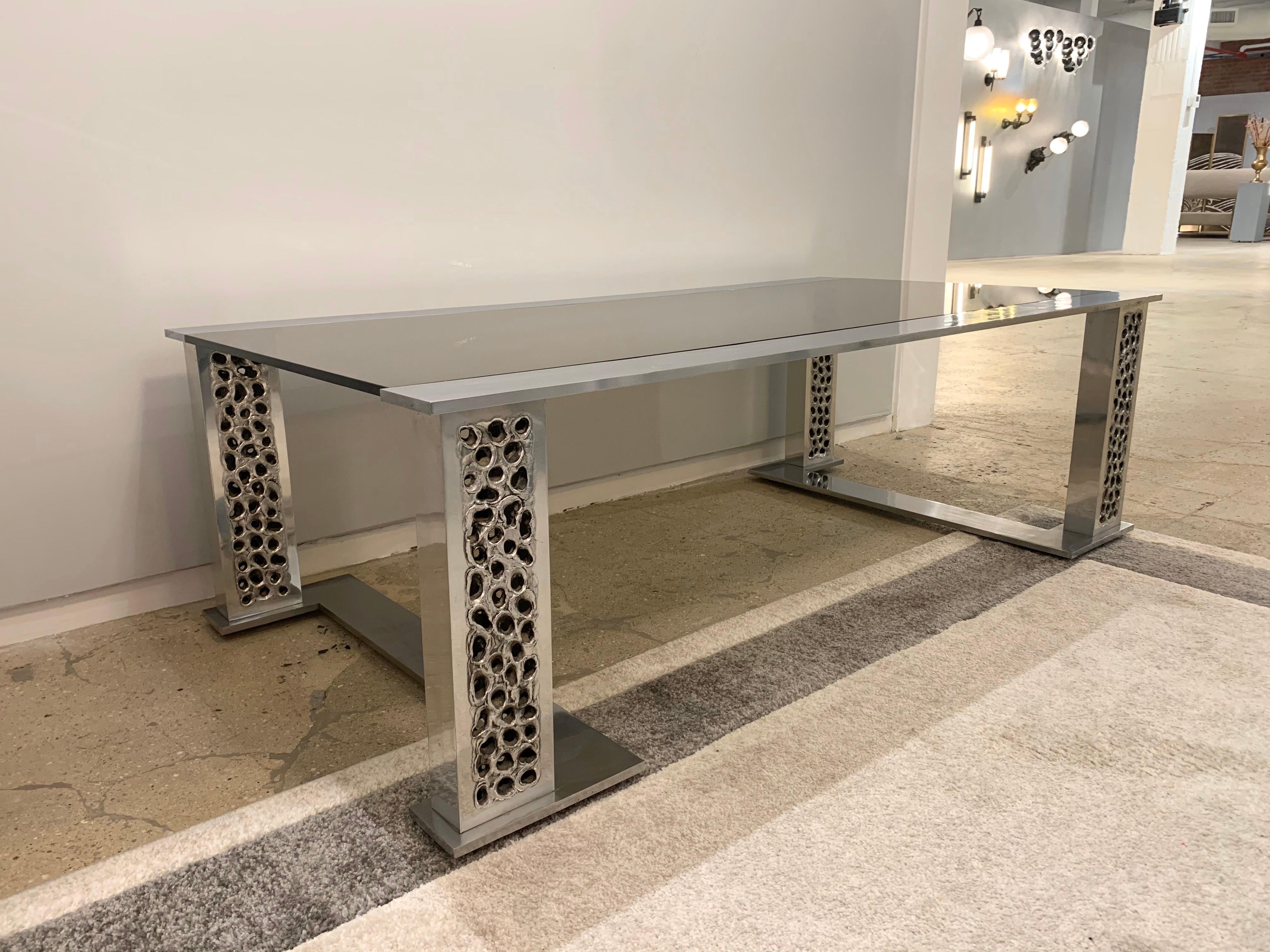 A rare original 1970s handmade burnt and hammered aluminum and smoked glass table by Belgian goldsmith, Willy Luyckx for Aluclair.


Willy Luyckx was a goldsmith who worked for goldsmith Camille Colruyt before starting his own business in the