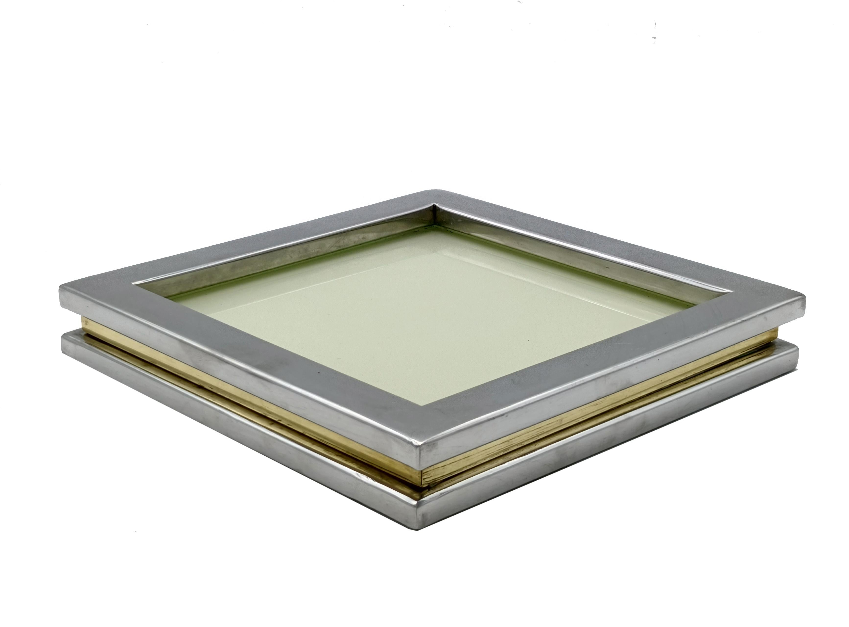 Preciosa bandeja de ordenación fabricada íntegramente en cromo y latón. Diseñada en Italia en la década de 1970 y atribuida a una producción de Willy Rizzo.
Este precioso objeto decorativo tiene un marco cuadrado de metal cromado con un marco