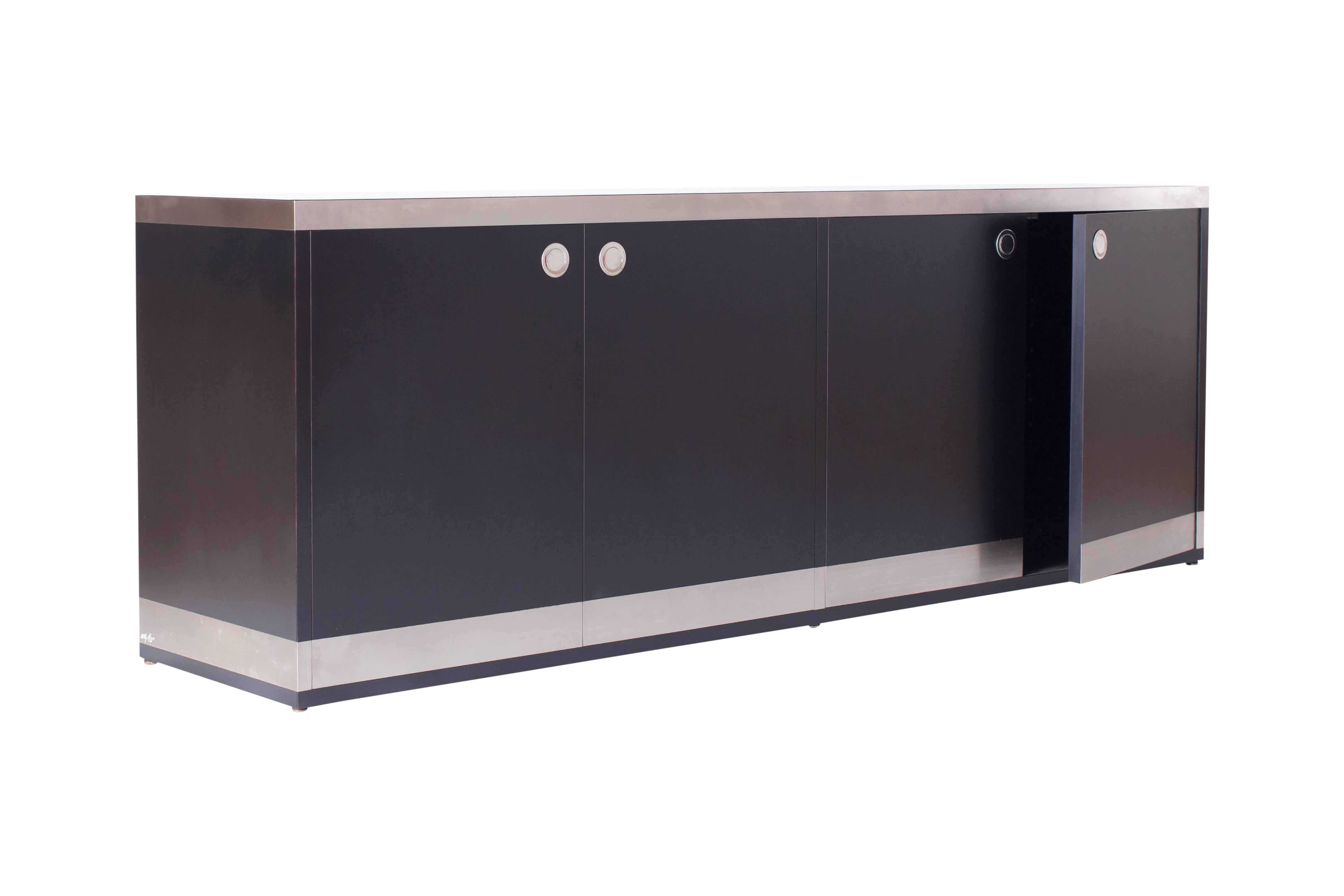hollywood regency  sideboard in black and chrome designed and produced
by Willy Rizzo, Italy, 1970s

The cabinet is equipped with four doors, providing plenty of storage space.
The cabinet on the left holds four drawers. Note the elegant details of