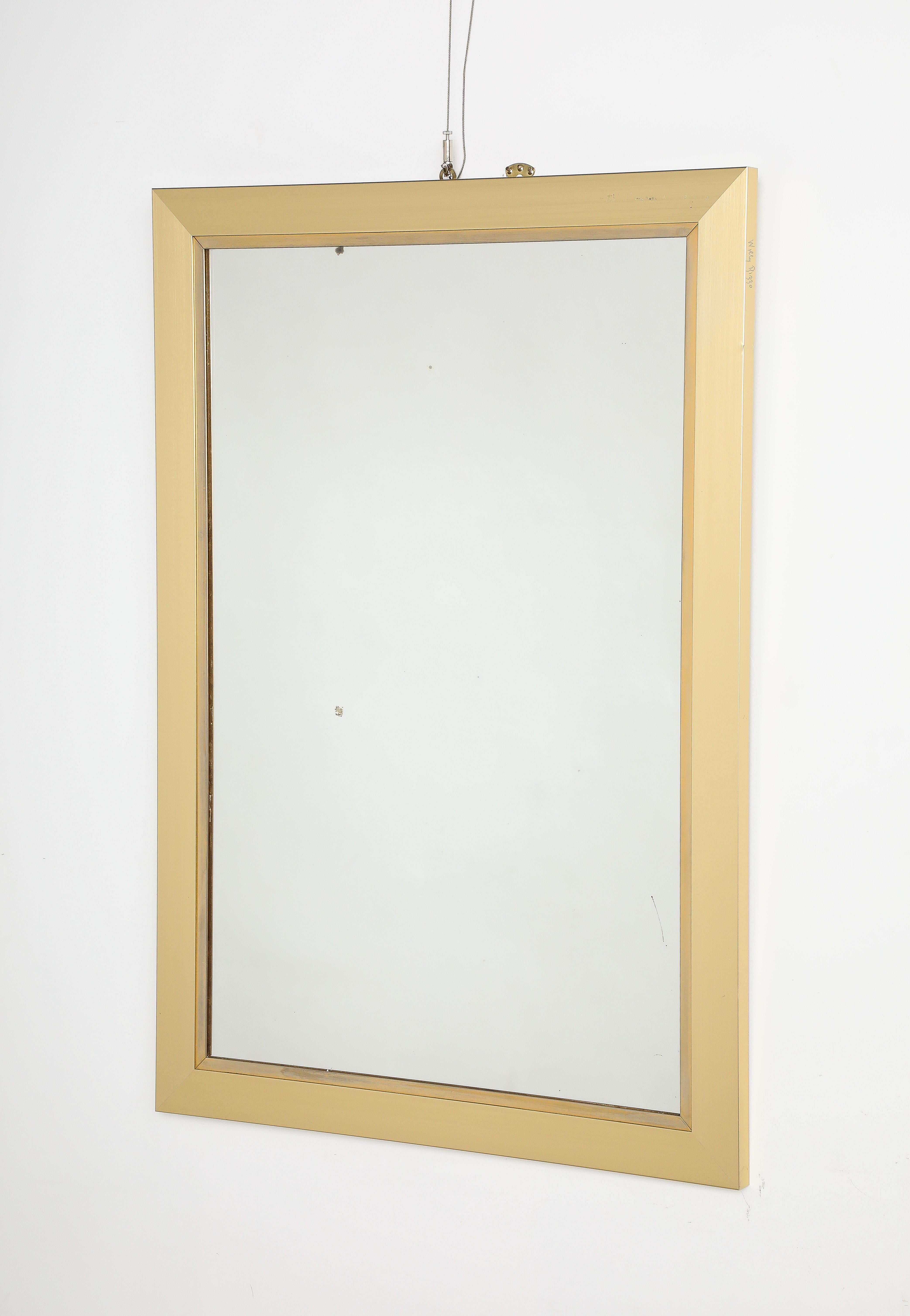 Celebrated luxury furniture designer Willy Rizzo designed this beautiful brushed brass wall mirror, circa 1970.  With sharp and clean lines, the piece is sleek and streamlined.  The brushed steel is a wonderful golden hue which highlights the