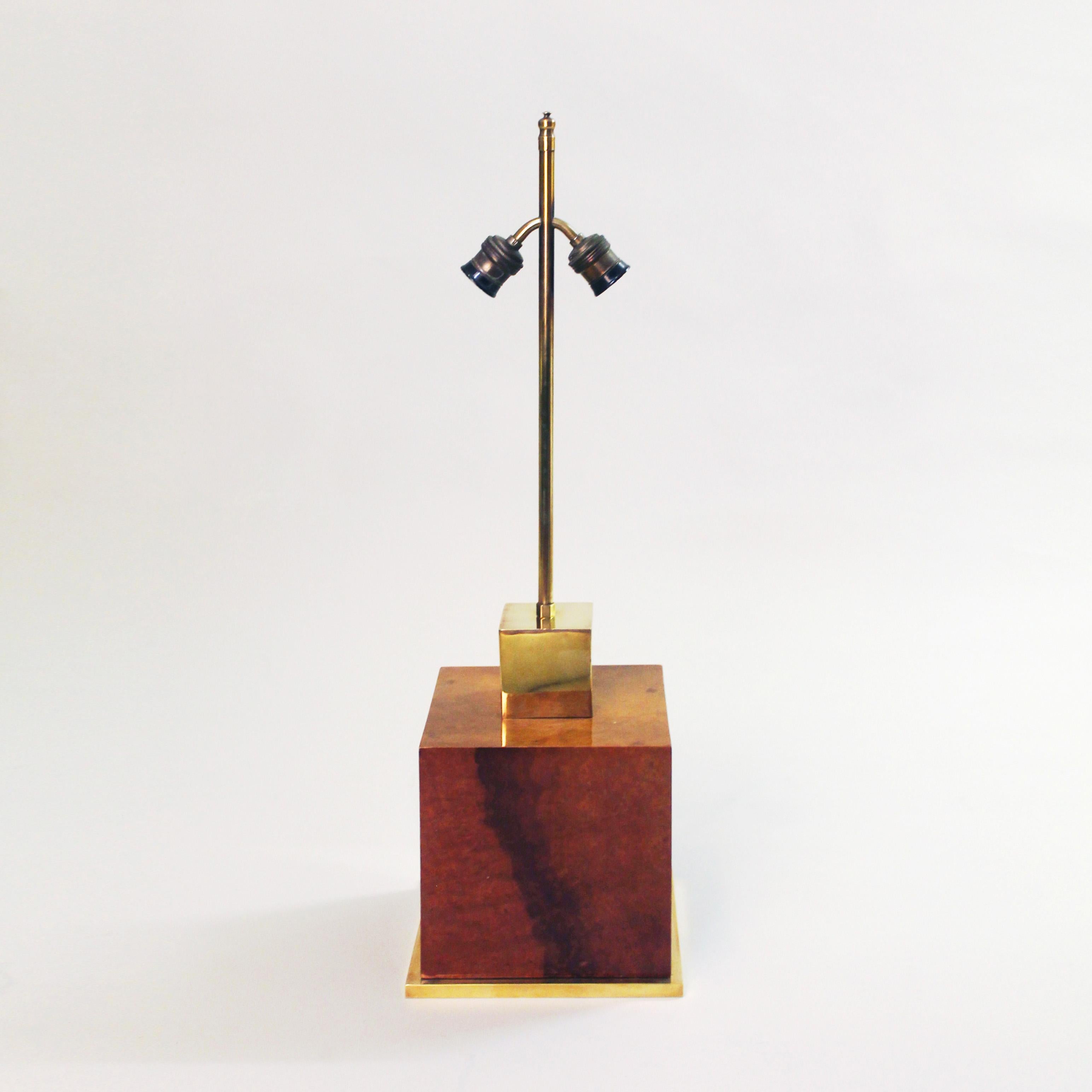 A simple but amazing table lamp in the manner of Willy Rizzo. A large burl walnut lacquered cube body is flanked between a brass base trim and the brass cube and finishings on top. 
The burl wood is beautifully book-matched giving a visually