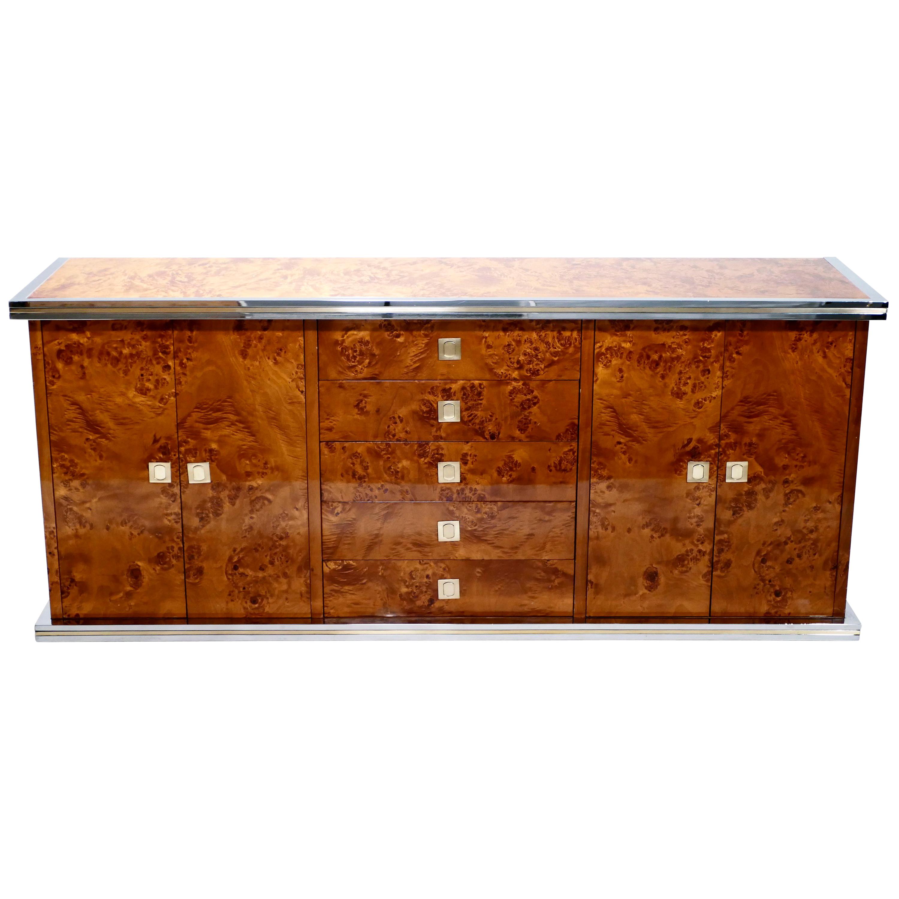 Rich burl wood is the eye-catching chief material in this beautiful, rare credenza by Willy Rizzo. The wood sides and top swirl and ripple into shades of caramel and coffee brown, for a warm, glossy look. Brass and chrome accents, along the clean