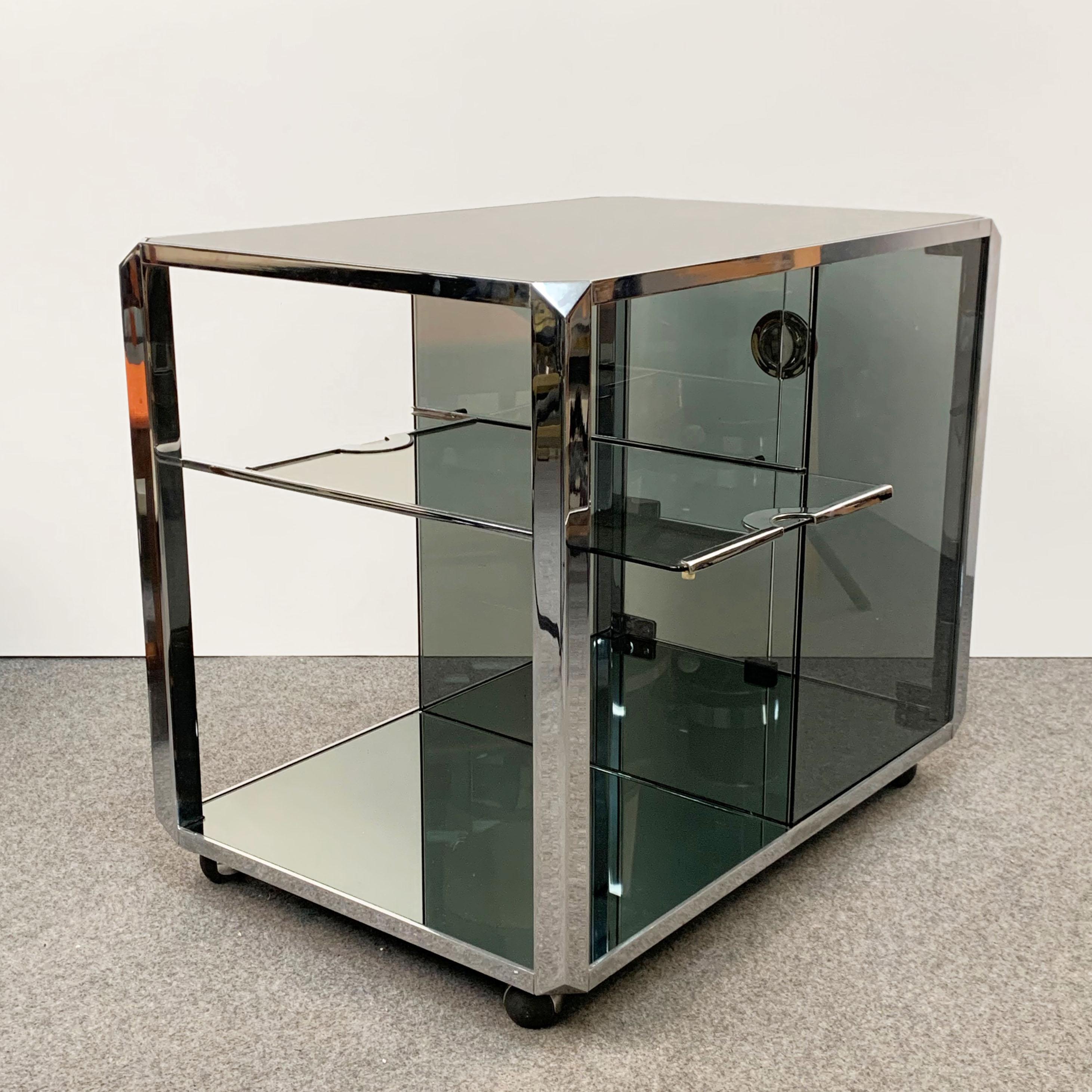 Elegant glass bar trolley with smoked mirrors and heavy chrome finishes. The attention to detail on this cart is second to none as it was designed by Willy Rizzo for Mario Sabot. It is an Italian production from the 1970s.

This masterpiece has