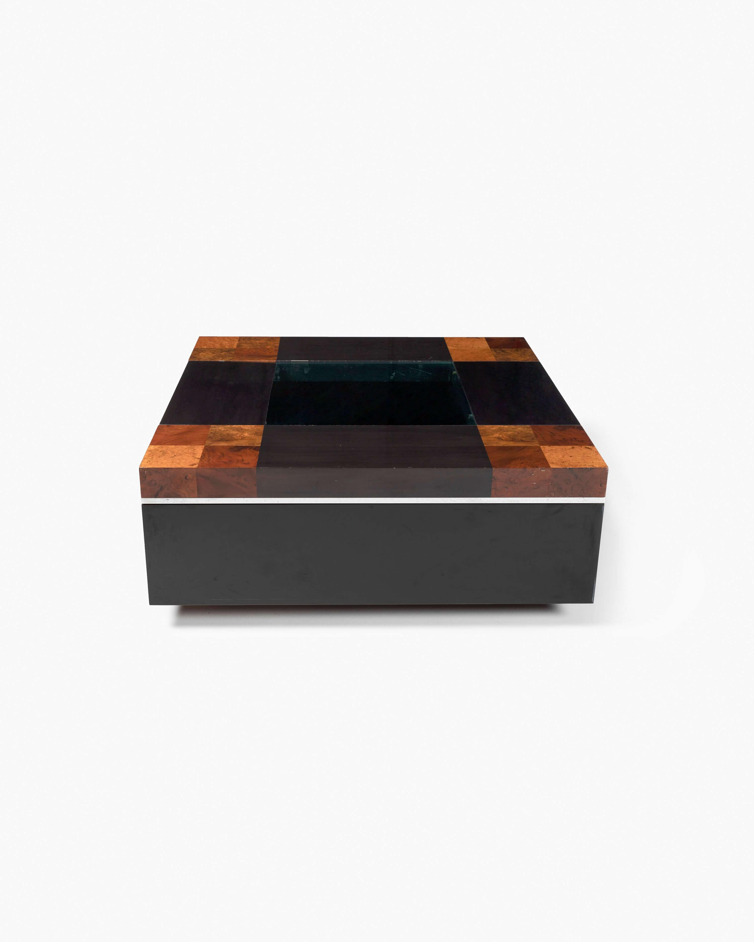 This coffee bar table by Willy Rizzo, emulative of the Art Deco influence during the 1970s, features a checker-like top with contrasting panels of rich brown burl and dark-stained wood veneer with a green-tinted glass center. The edges of the table