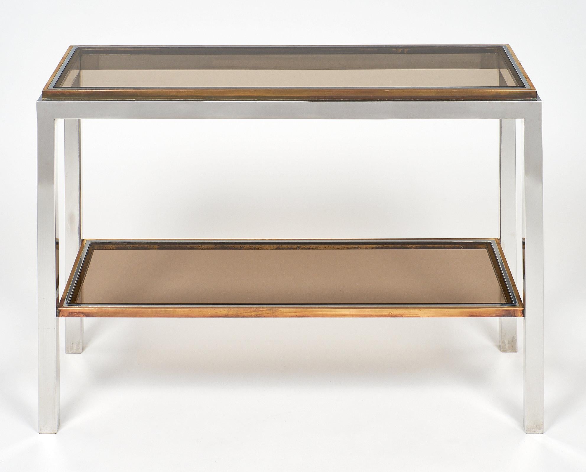 Rare Willy Rizzo console table. This Italian chromed steel two tier console has brass trim and features tinted glass top and shelf.