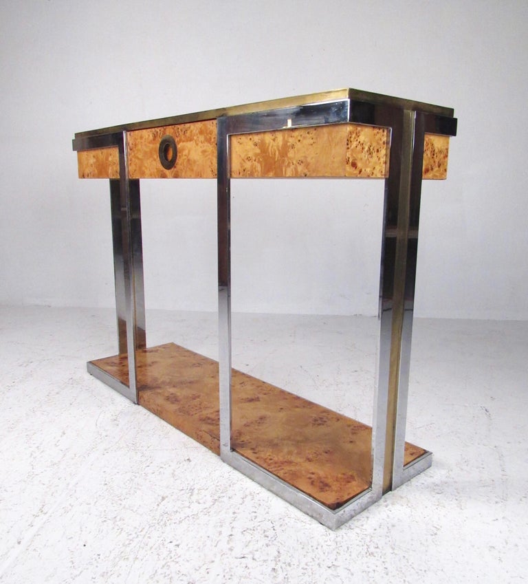 This stylish Italian modern console table makes an elegant hall or entry table with an impressive mixture of vintage brass, chrome, and natural burl wood. Single drawer for convenient storage has a brass ring handle, while the complimenting contrast