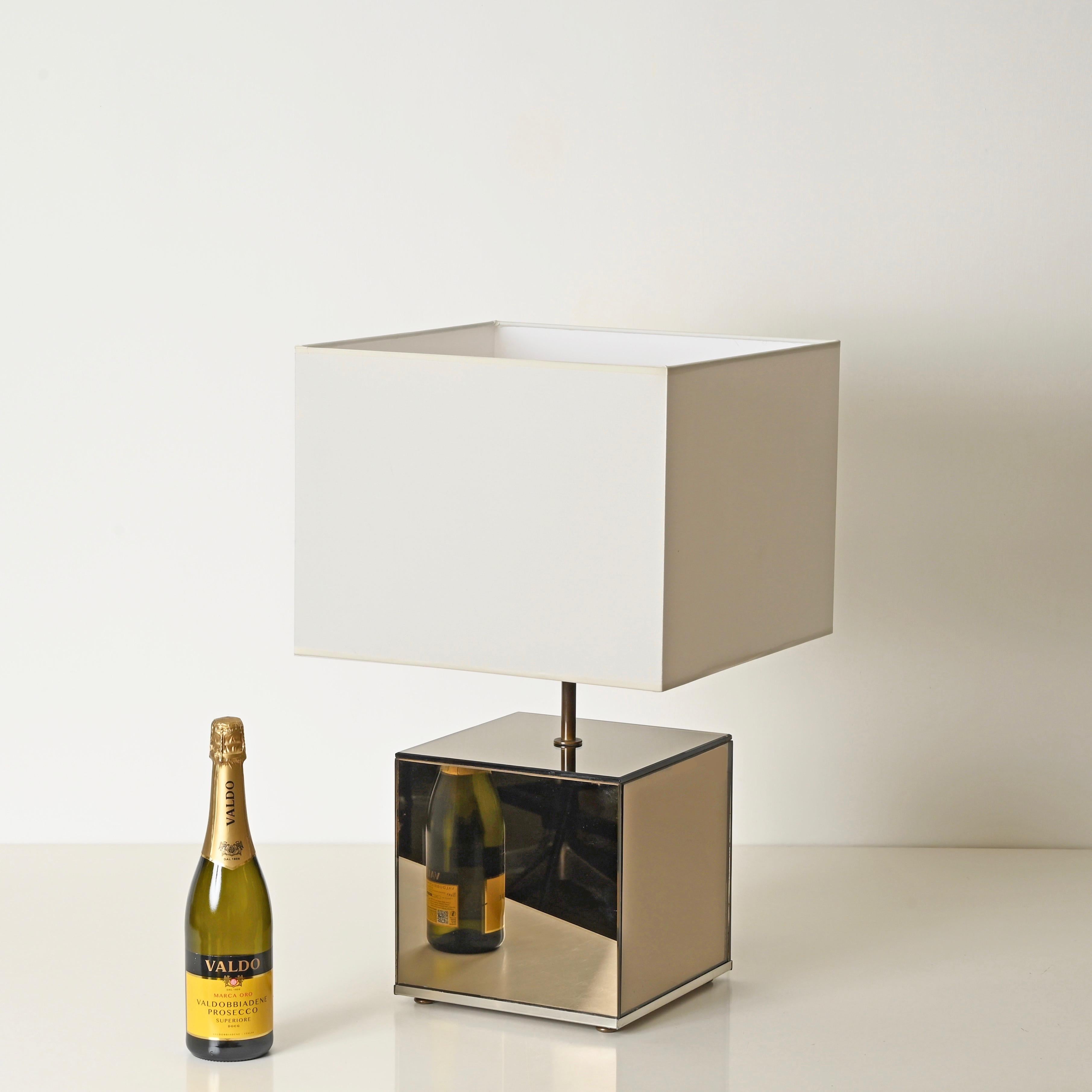 Spectacular “Cube” table lamp fully made of smoked bronze mirrors and chrome-plated metal, completed with a white cotton lampshade. This charming and unique lamp was designed by Willy Rizzo and produced in Italy during the 1970s.

In amazing