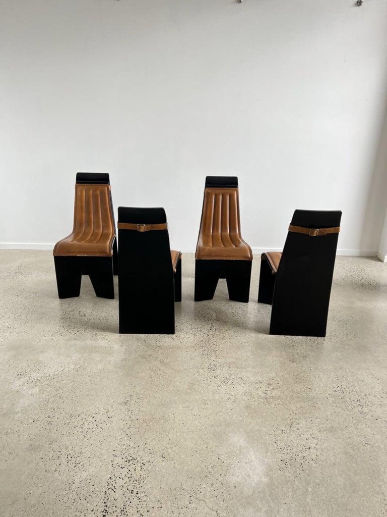 Unique Willy Rizzo for Mario Sabot set off four dining chairs made of curved wood lacquered in black shiny colour and leather padded cushions, custom made for these chairs, and hold with strong belt buckles.