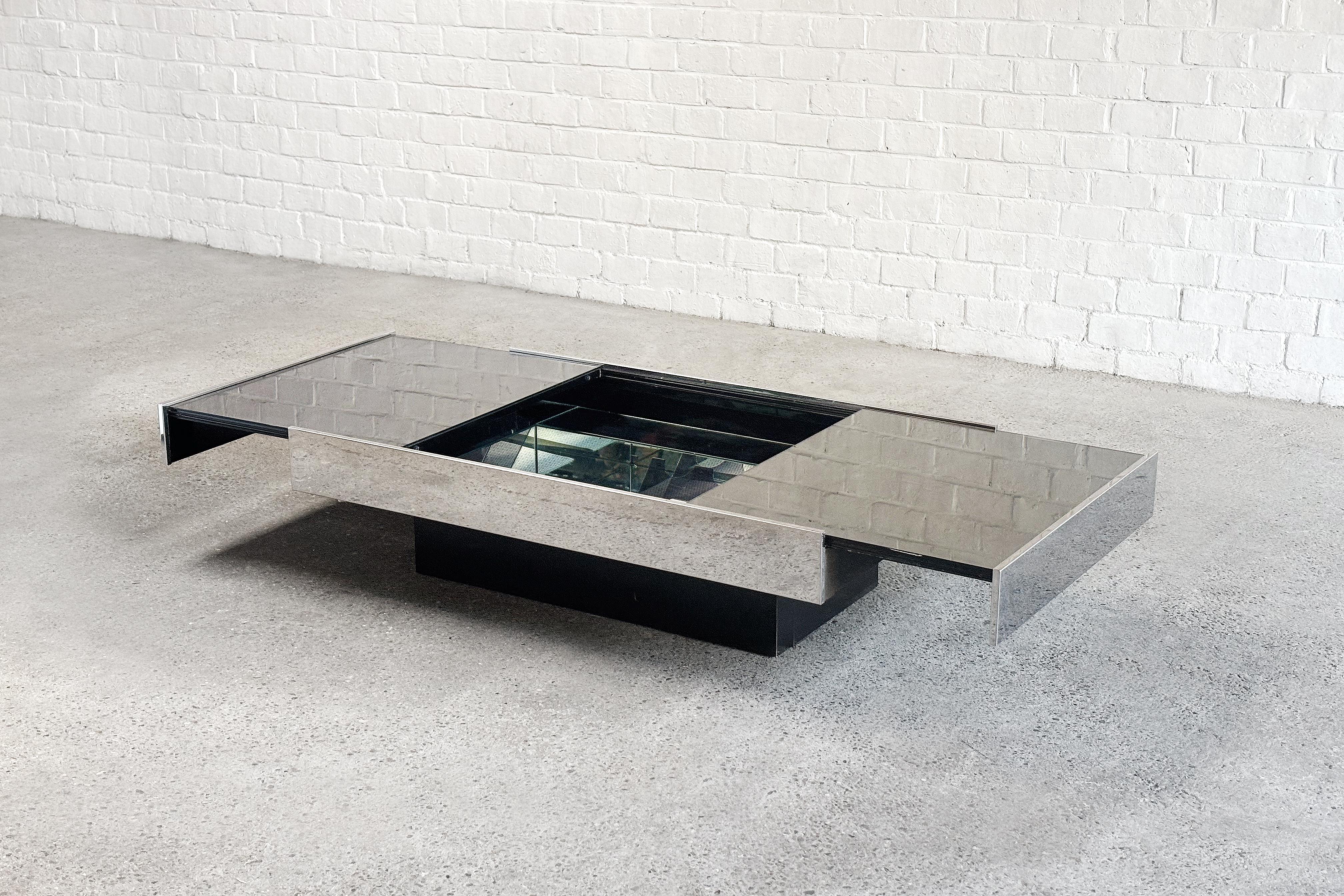 Spectacular Italian Coffee table designed by Willy Rizzo for Cidue,  circa 1970. When extended, this table contains a hidden mirrored dry bar with plenty of storage room. It features a chrome frame raised on a lacquered black wooden base topped with