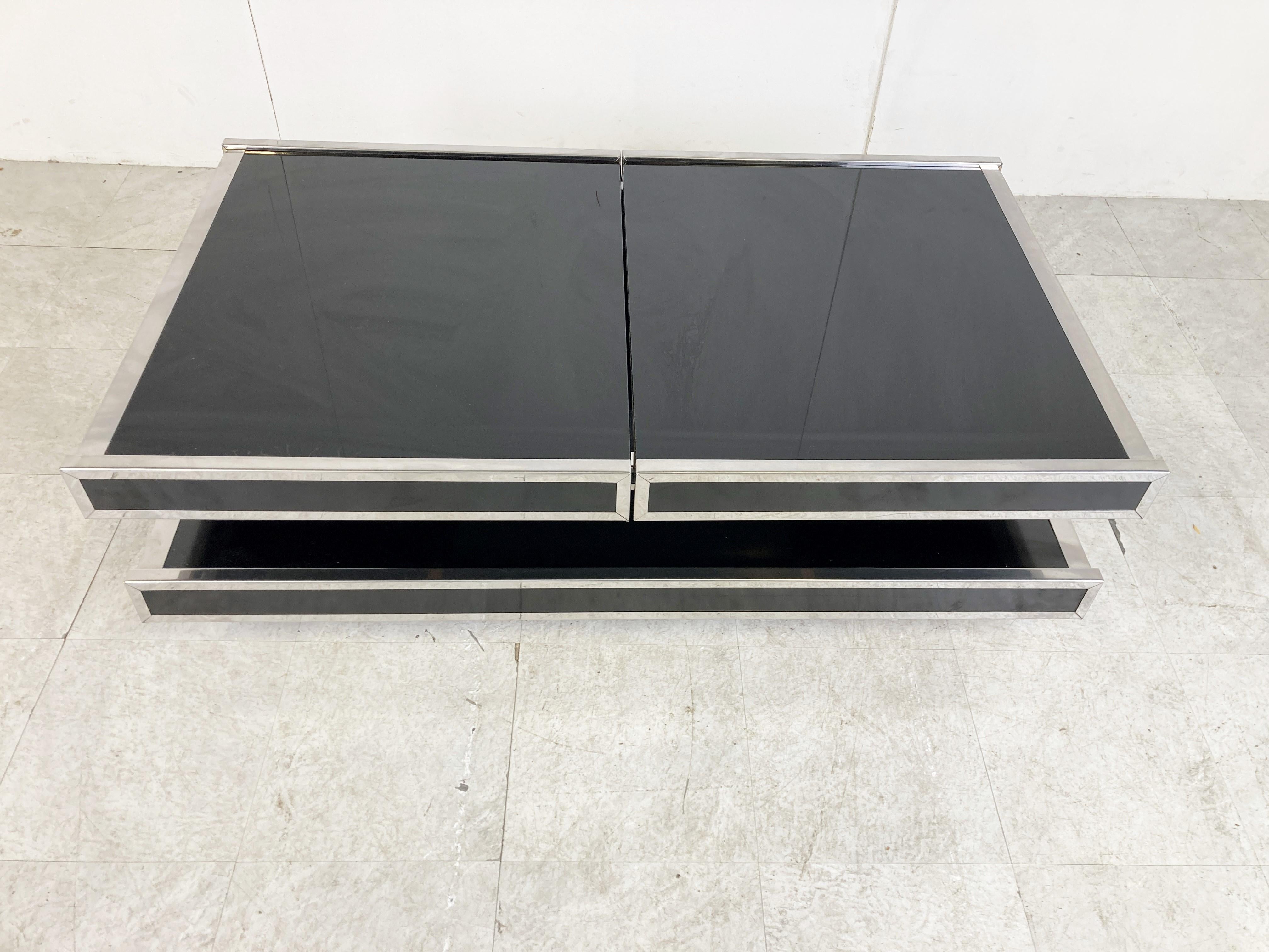 Black lacquered coffee table with sliding table tops revealing an aluminum bar compartment ideal to store bottles and glasses.

Designed by Willy rizzo for Mario Sabot.

The table is in a original vintage condition with normal age related