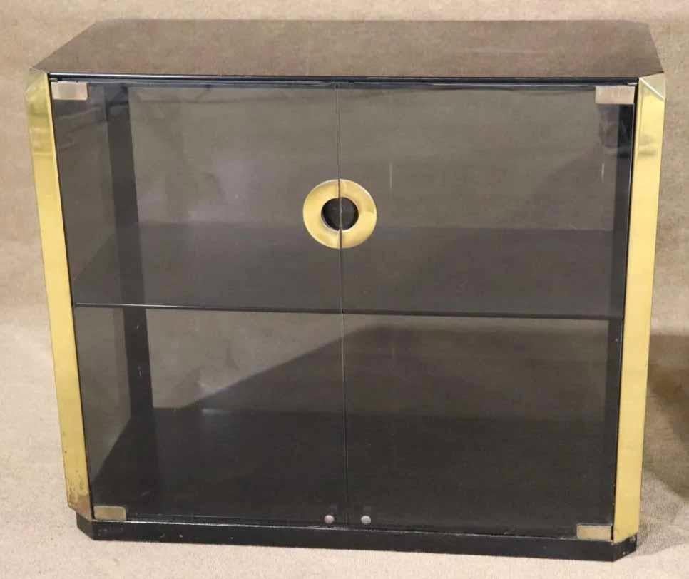 Pair of Mid-Century Modern Italian glass cabinets designed by Willy Rizzo. Smoked glass with accenting brass hardware.
Please confirm location.