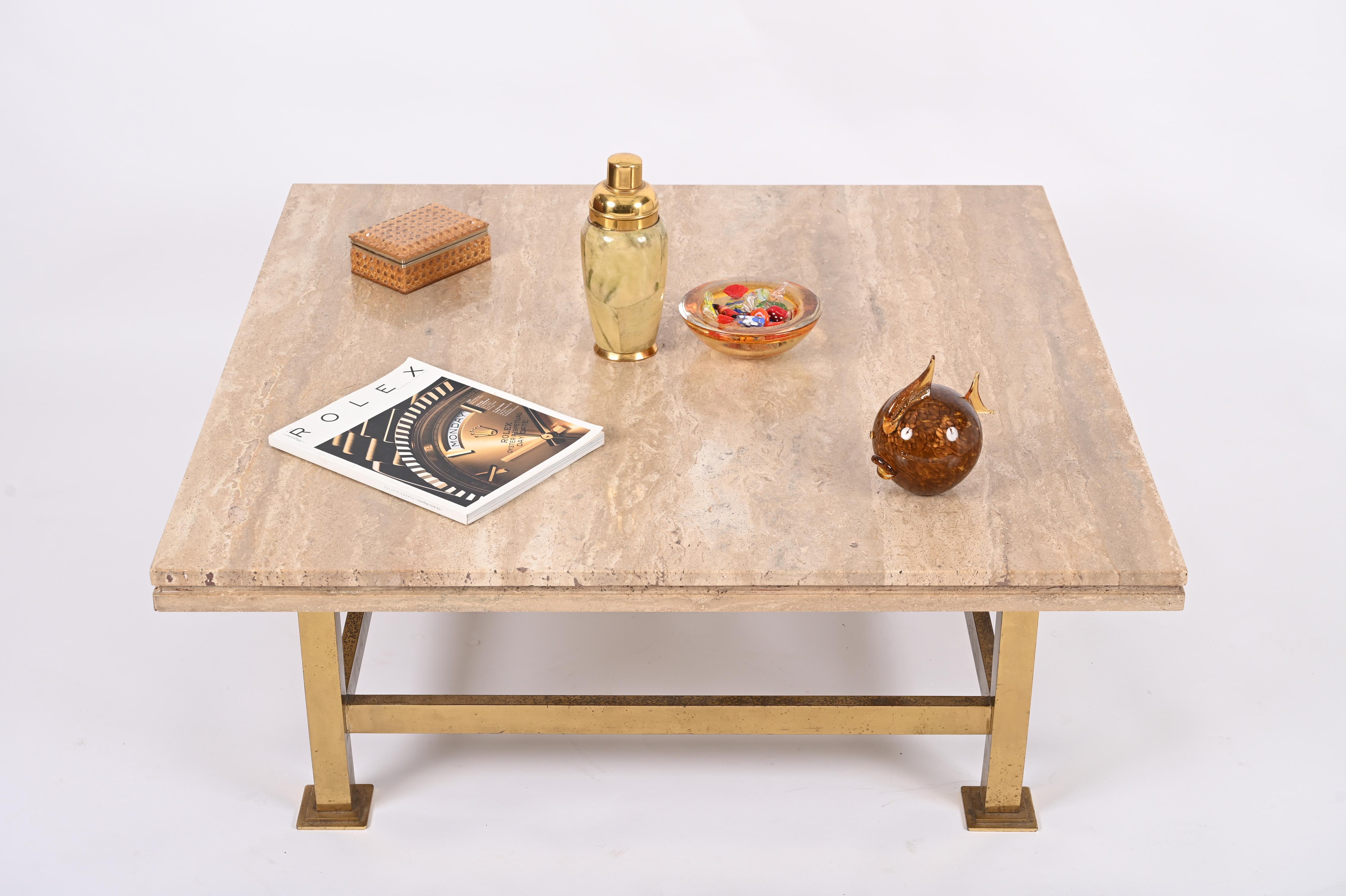 Midcentury square coffee table in travertine marble with brass base. This exceptional object was designed in Italy in the 1970s in the style of Willy Rizzo.

This stunning table features brass base and an outstanding quality Travertine marble top.