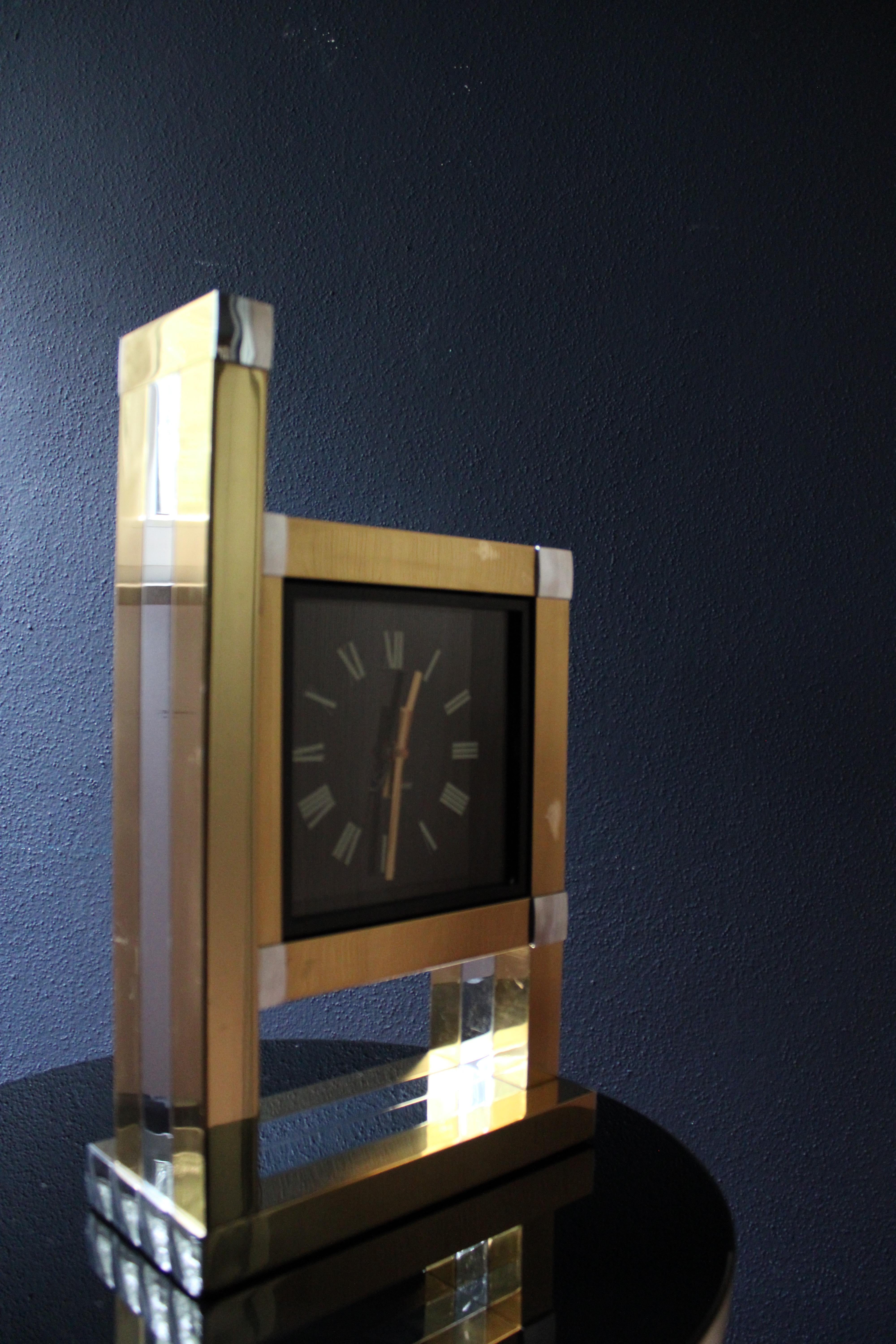 Dies ist ein seltener Fund! Wir freuen uns, diese glamouröse kubische Wanduhr aus den 1970er Jahren, entworfen von Willy Rizzo und hergestellt von Lumica, auf den Markt zu bringen. 

Diese Uhr aus vergoldetem, zweifarbigem Metall ist in insgesamt