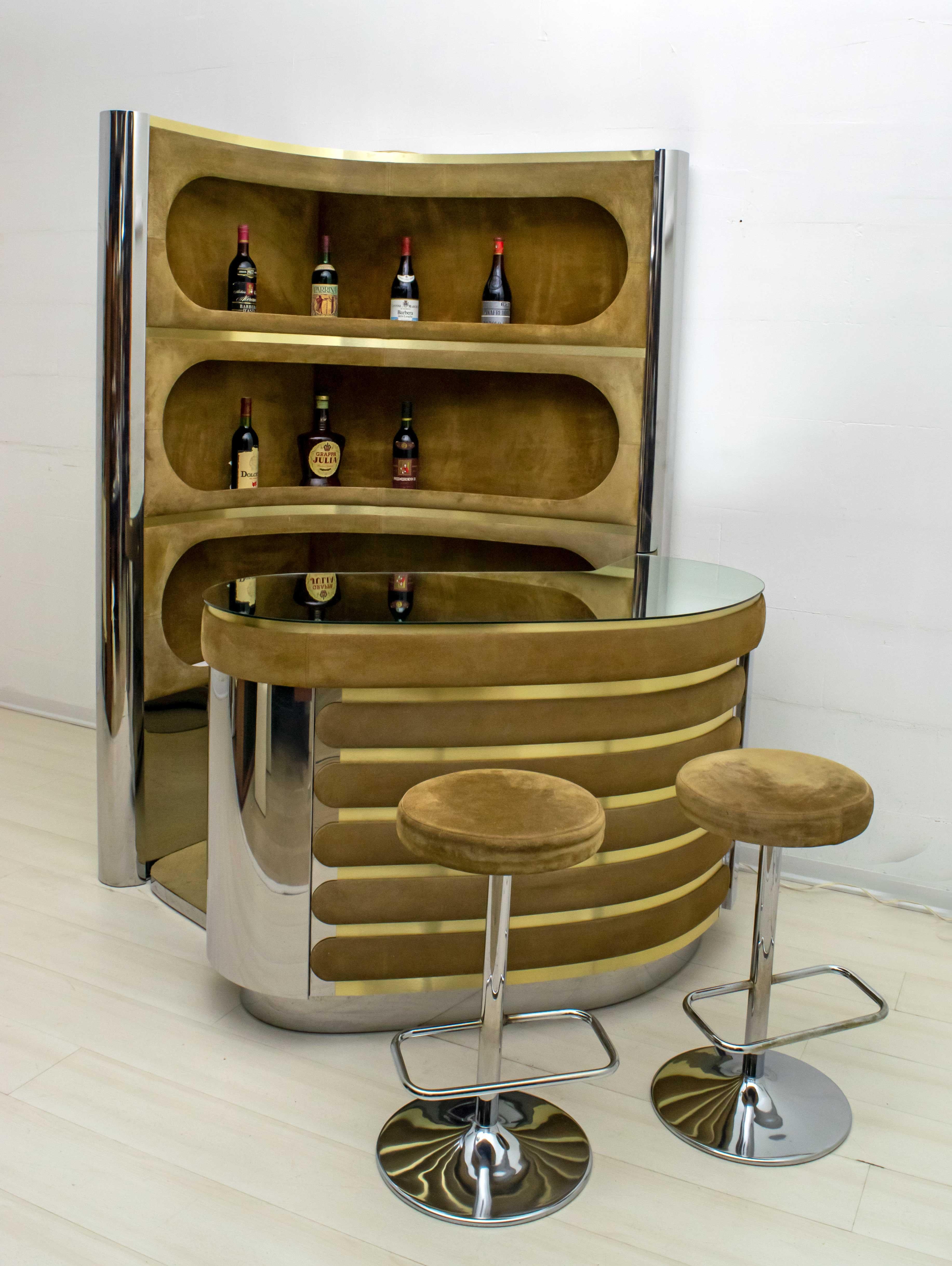 This bar designed by the famous Italian design Wlly Rizzo, is covered in suede and steel, including a minibar and two stools, the piece of furniture can be positioned at an angle, or placed on a single wall because it is finished on one side by a