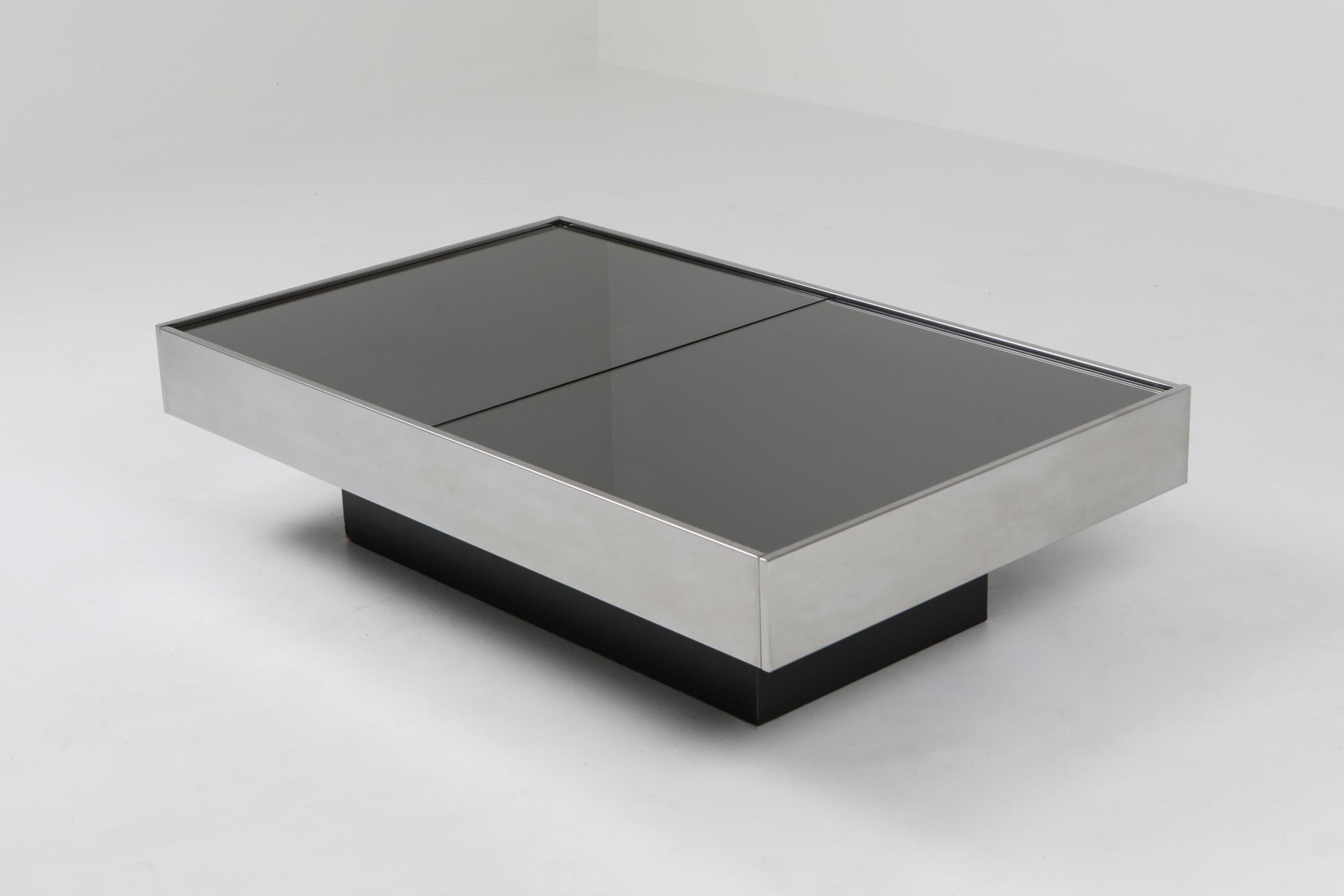 Postmodern coffee table, Willy Rizzo, Cidue, Italy, 1970s

Italian glam piece that fits well in a Hollywood Regency inspired eclectic decor.
Rectangular coffee table on a black laminate base, chromed steel frame and silver mirrored glass top