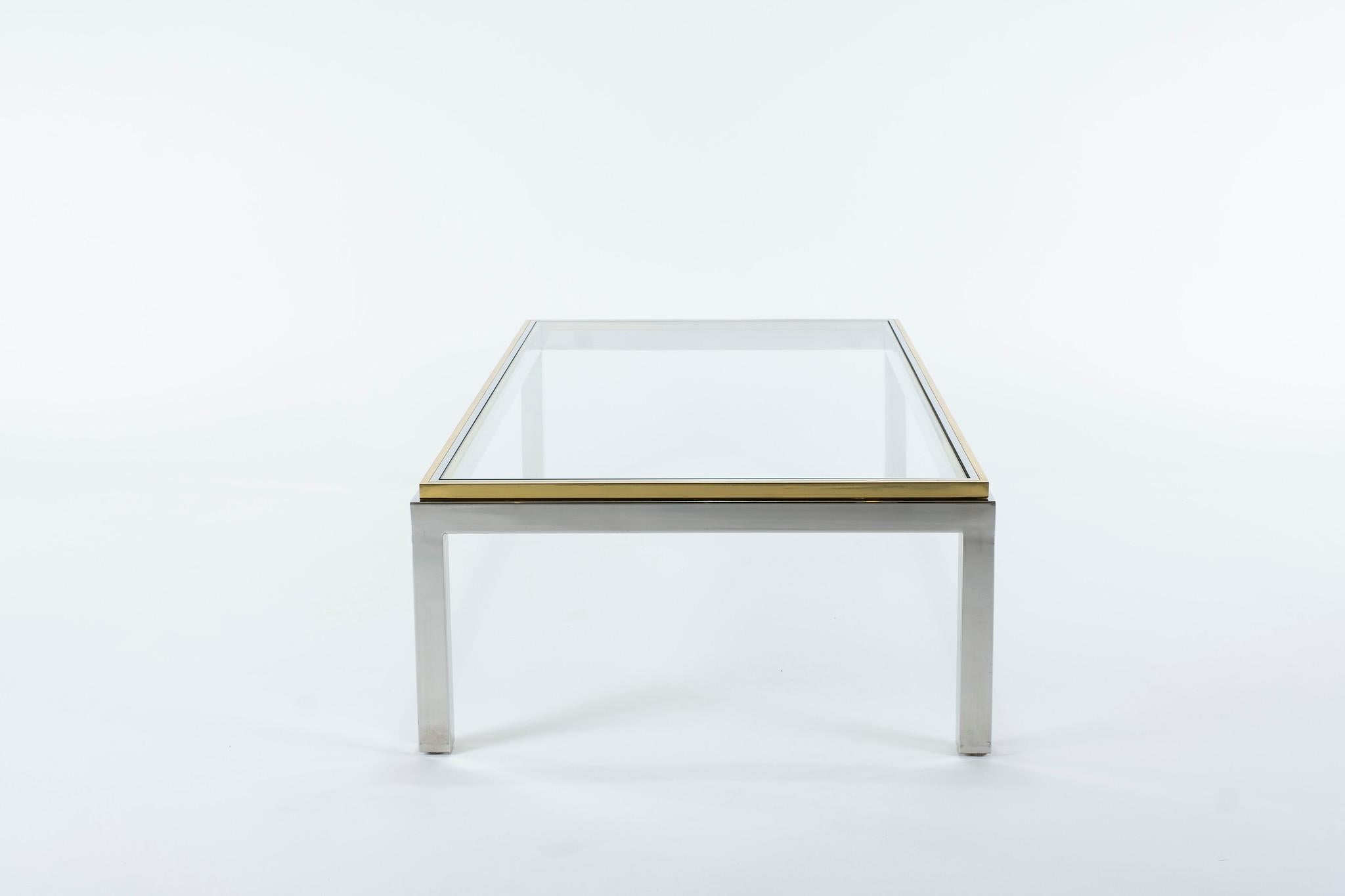La table basse classique Willy Steele modèle Flaminia se caractérise par un cadre en acier poli avec des bords en laiton et un plateau en verre.