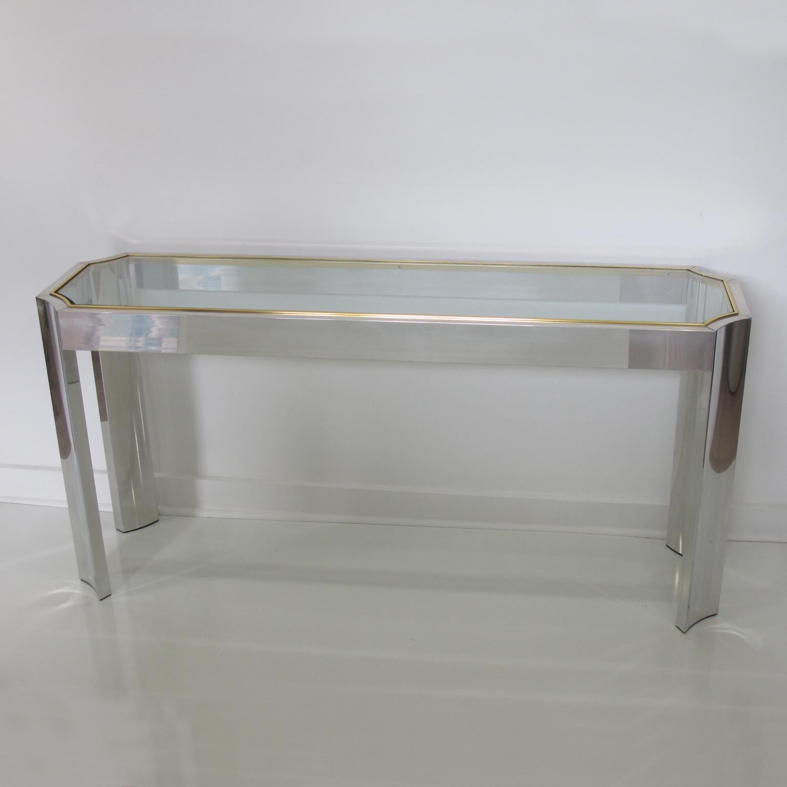 This superb modernist console or sofa table in aluminum and brass is reminiscent of the work of Willy Rizzo in the 1970s. Beautiful and functional, this sofa table is an obvious choice. The piece features an elongated, sleek shape with an octagonal