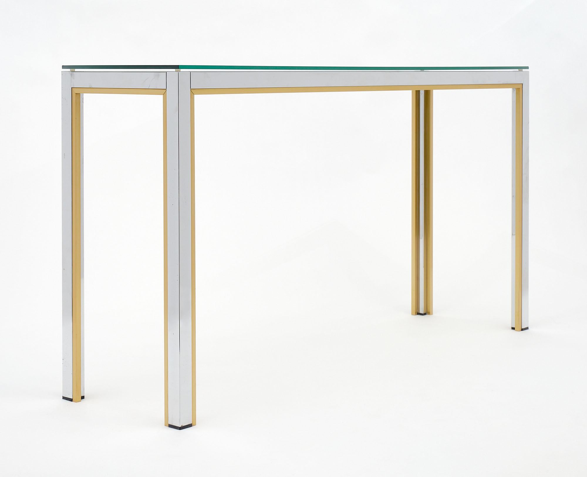Console, Italian, Mid-Century Modern made of chromed steel and brass with a clear glass top. It is in the style of designer Willy Rizzo.