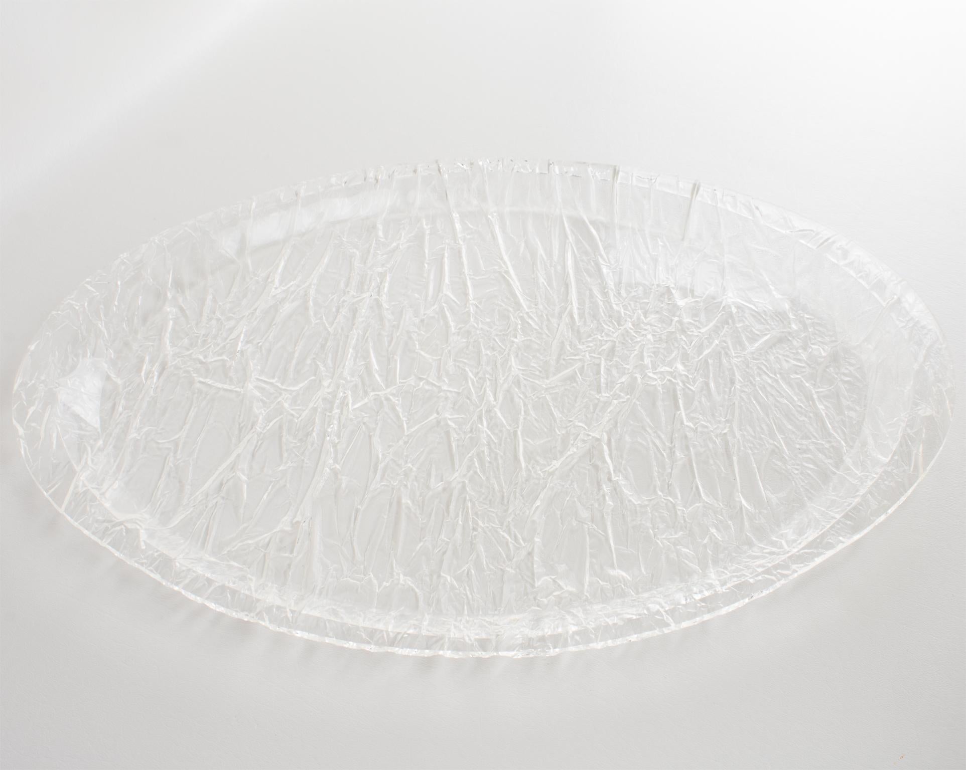 Ce plateau de service ou plat de bar moderniste et raffiné des années 1970 a un design qui rappelle les œuvres de Willy Rizzo. Fabriquée en Italie, la forme ovale du grand majordome est fabriquée en Lucite cristalline avec un étonnant motif moulé et