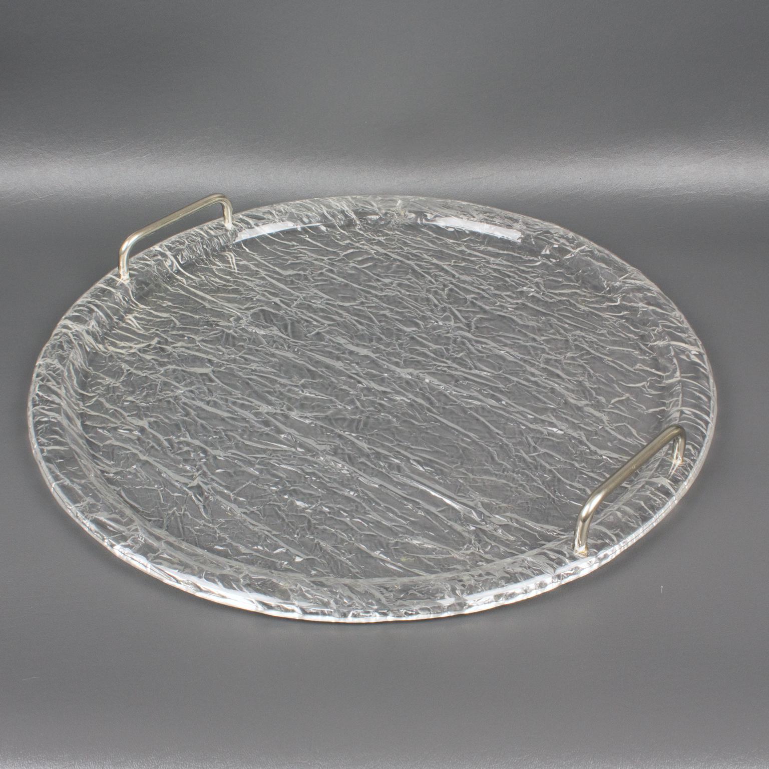 Refined 1970s modernist barware serving tray platter, design attributed to Willy Rizzo. Large round shape with crystal clear Lucite in a stunning wrinkled molded pattern that gives a frosty effect and two chromed metal handles.
Measurements: 17.13