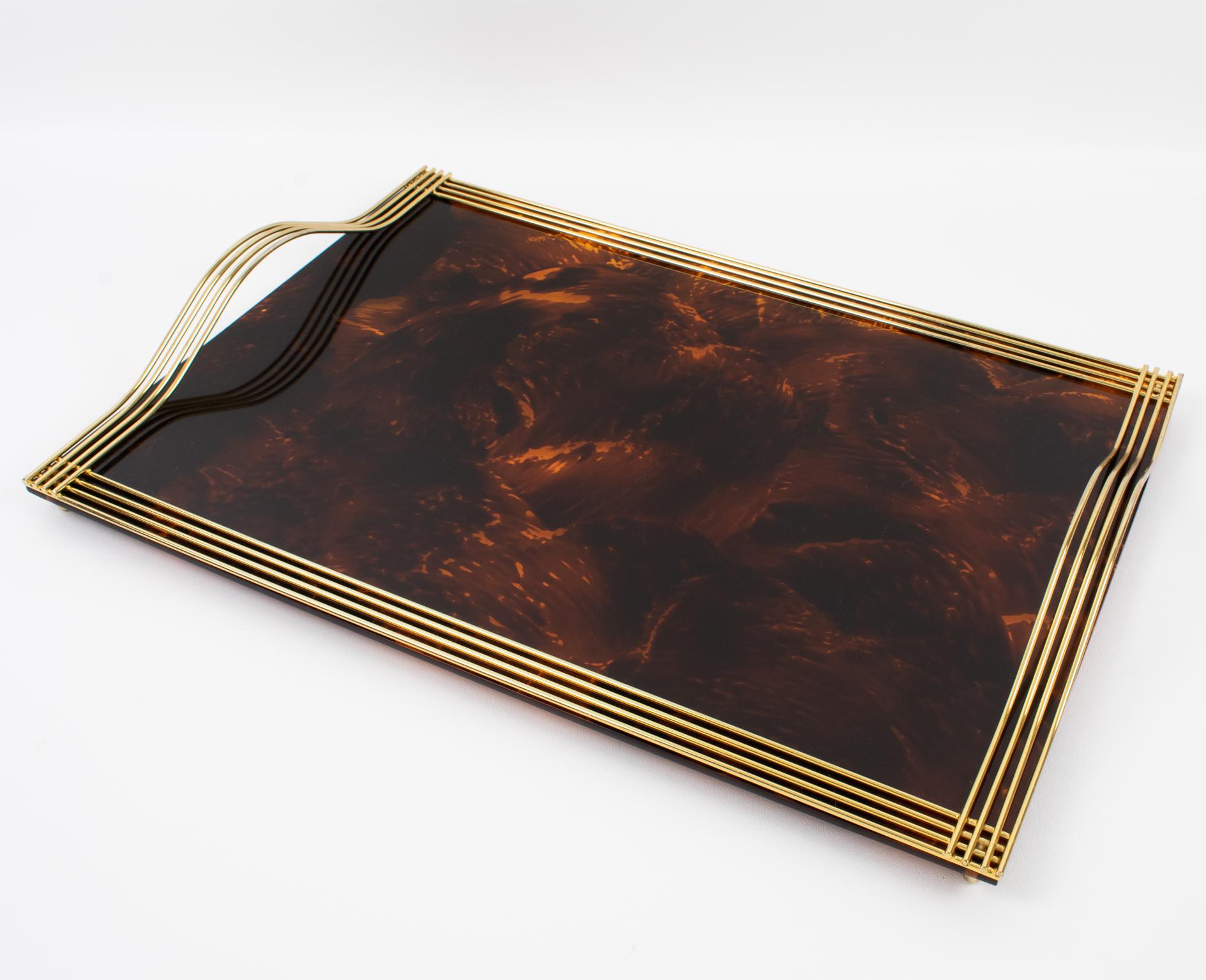 This elegant Mid-Century Modern barware serving tray was crafted in Italy in the 1970s. Its design is attributed to Willy Rizzo. The large rectangular butler shape has a gilded brass raised gallery and handles and a Lucite base in a tortoiseshell