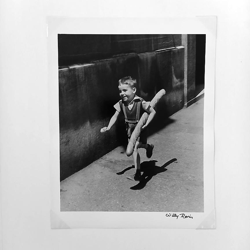 Une photographie très recherchée Le Petit Parisien, 1952 par le photographe français Willy Ronis est une image en noir et blanc, un tirage à la gélatine argentique, mesurant 30 x 23,5 cm.  12  x 9in. L'œuvre est signée au recto (avant de la photo)