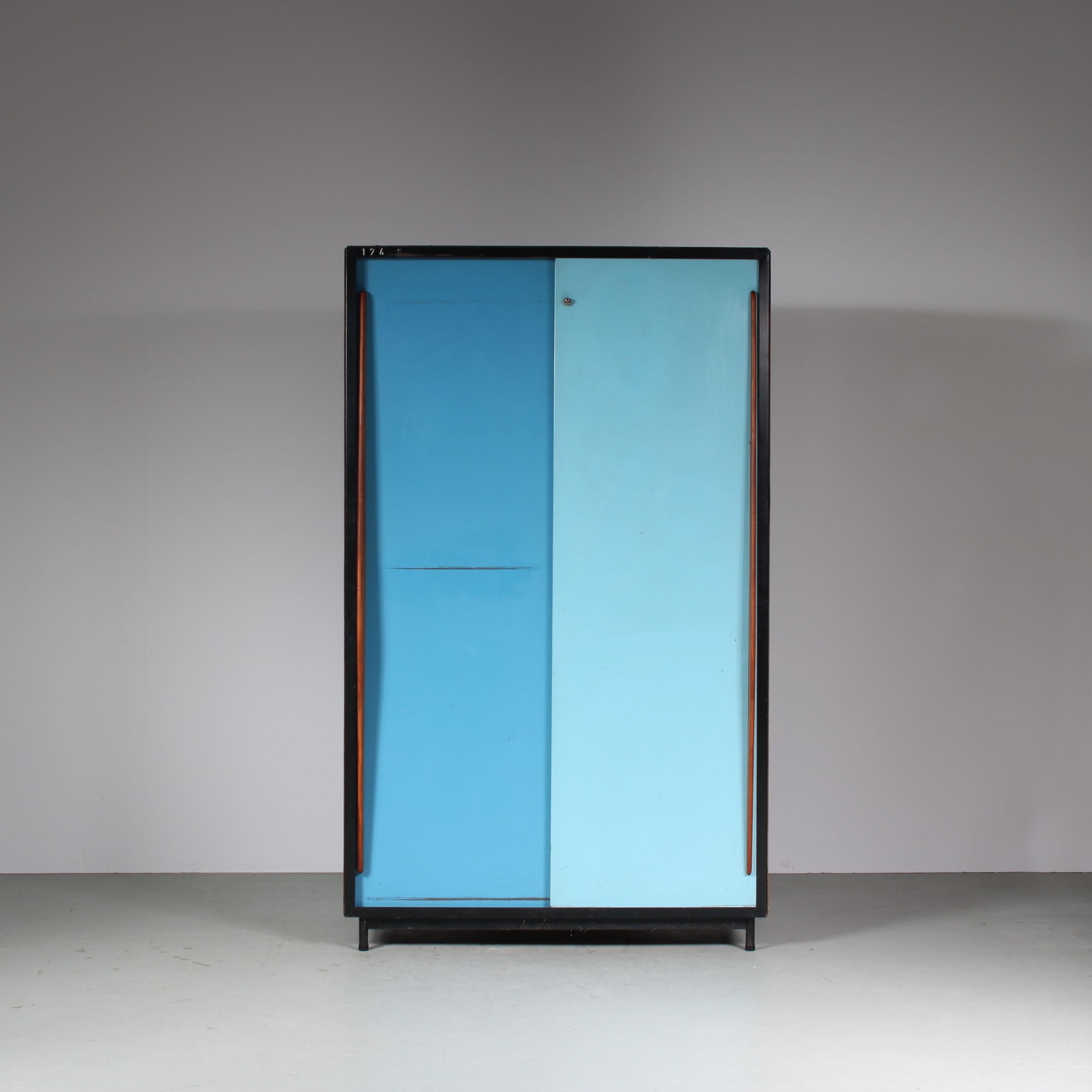 A fantastic large wardrobe designed by Willy Van Der Meeren, manufactured by Tubax in Belgium in 1952.

This eye-catching, rare piece is made of beautiful quality wood on a black metal structure. The large metal sliding doors are both executed in a