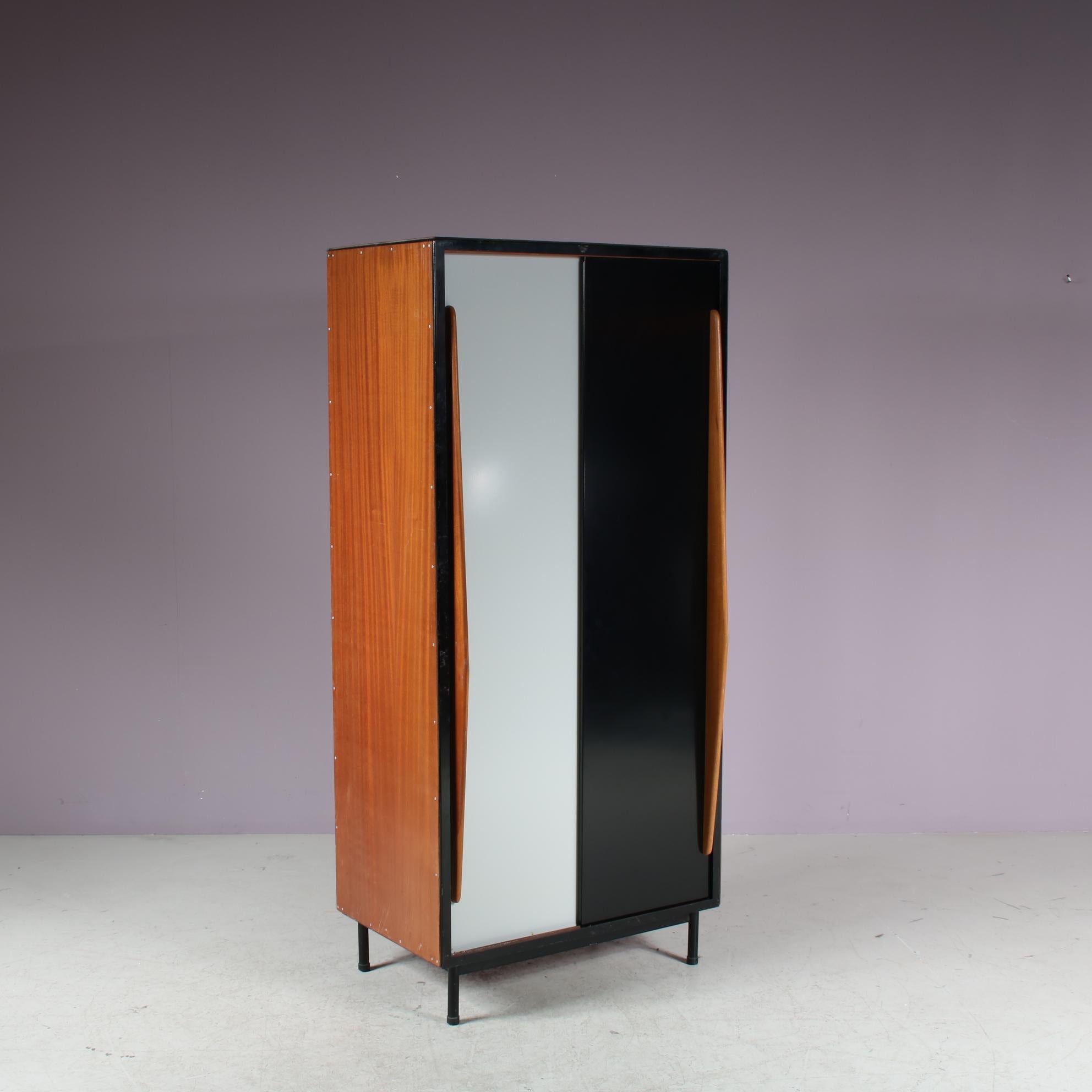 A fantastic wardrobe designed by Willy Van Der Meeren, manufactured by Tubax in Belgium in 1952.

This eye-catching, rare piece is made of beautiful quality wood on a black metal structure. The large metal sliding doors are executed in two different