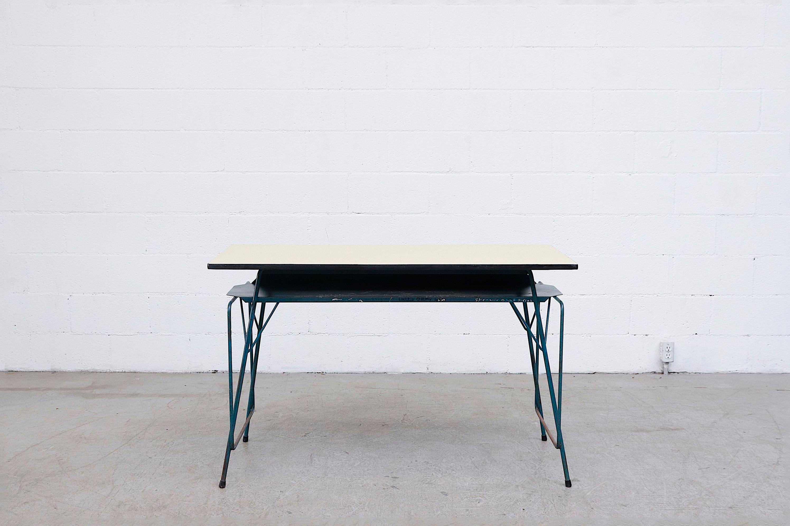 Midcentury Willy Van Der Meeren Industrial desk with Formica top and teal enameled tubular metal frame. In original condition with visible wear. Wear is consistent with it's age and use. This one has prominent graffiti, others available in varying