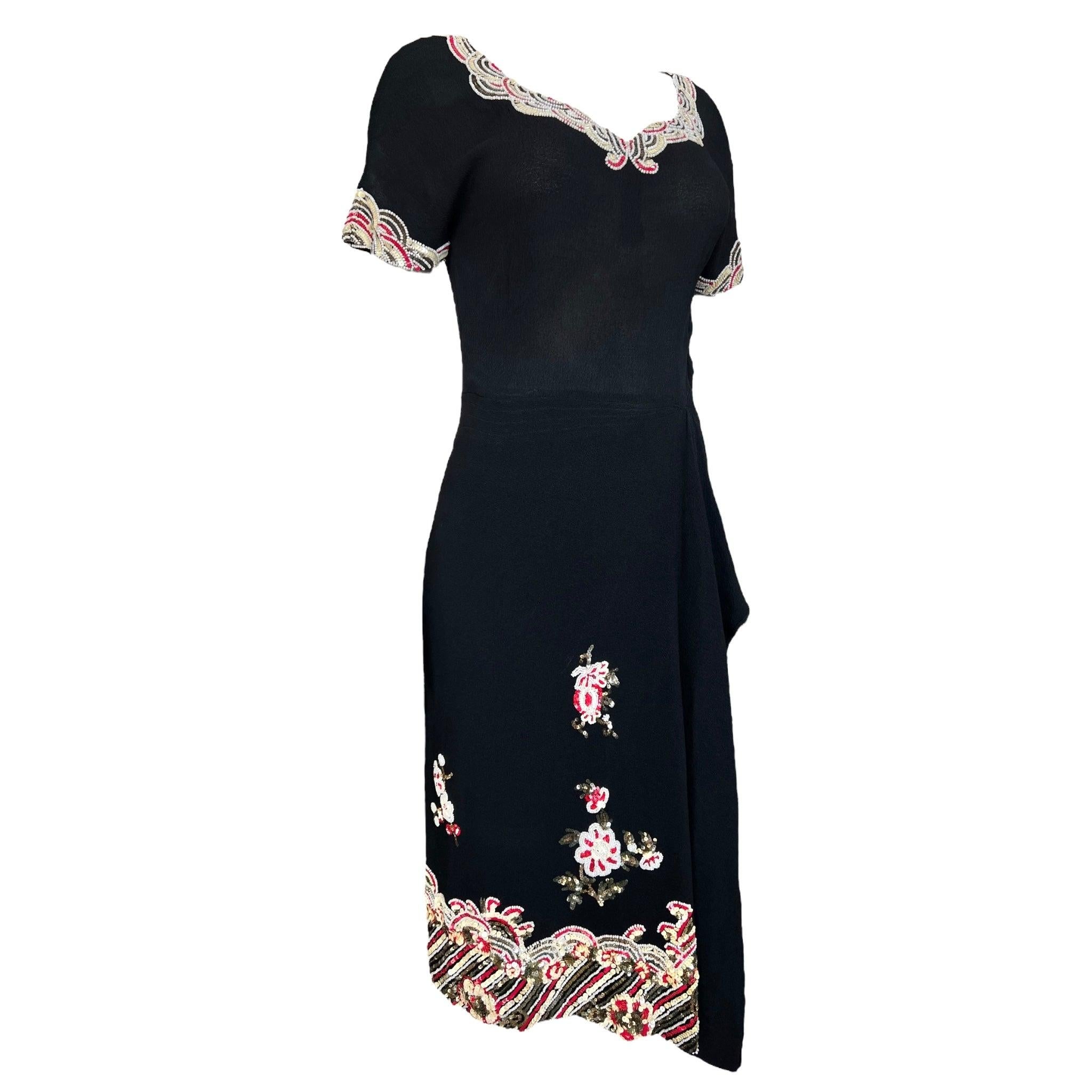 Flirty 1940's black crepe rlightweight wool crepe cocktail dress by the label Wilma. Intricate blossomed beading and sequins around the collar and sleeve cuffs. The lower half of the skirt front and back is decorated with red and cream seed beed